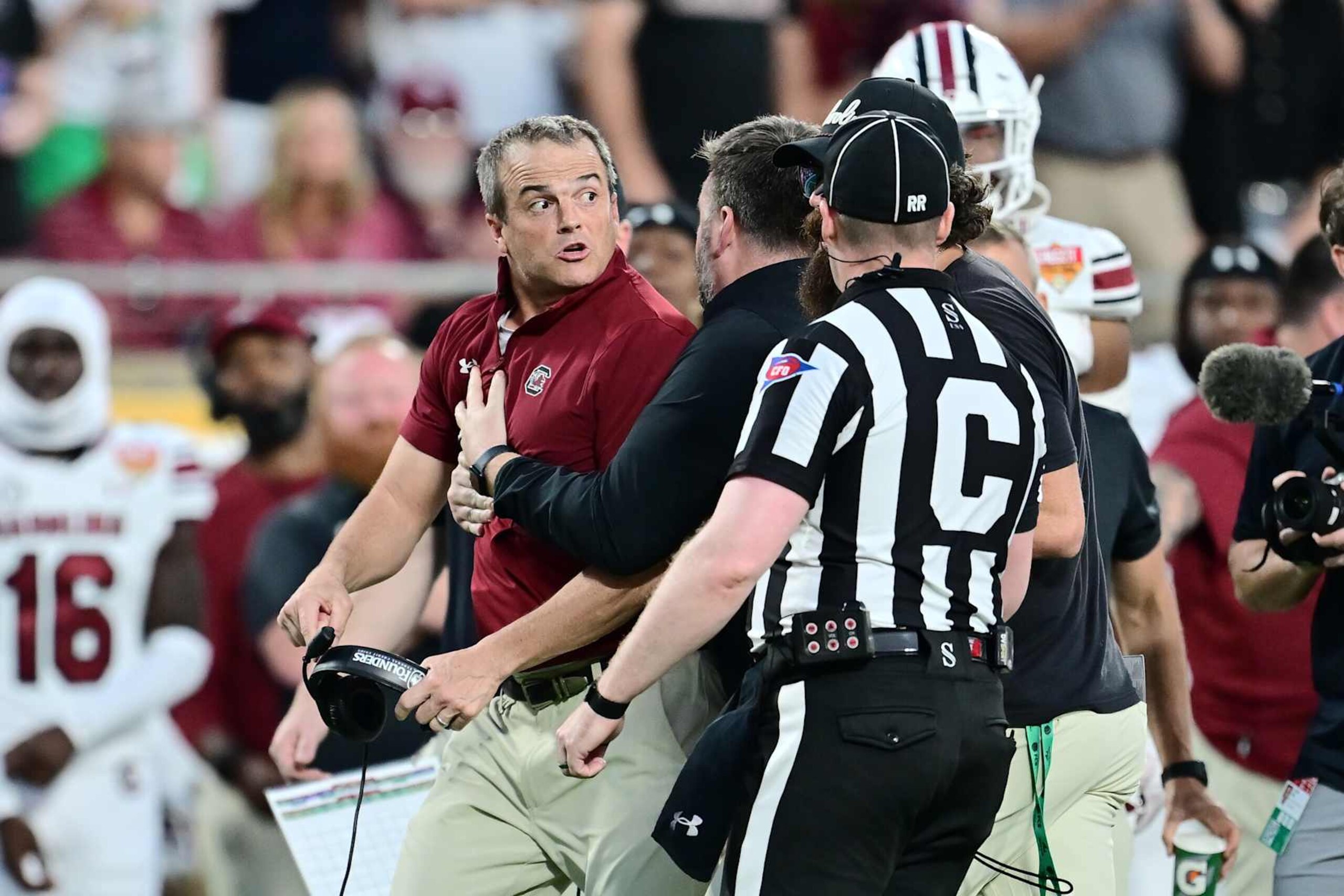 ORLANDO, FLORIDA - DECEMBER 31: Head coach Shane Beamer of the South Carolina Gamecocks is held back from the field during the second half of the 2024 Cheez-It Citrus Bowl against the Illinois Fighting Illini at Camping World Stadium on December 31, 2024 in Orlando, Florida. (Photo by Julio Aguilar/Getty Images) ORLANDO, FLORIDA - DECEMBER 31: Head coach Shane Beamer of the South Carolina Gamecocks is held back from the field during the second half of the 2024 Cheez-It Citrus Bowl against the Illinois Fighting Illini at Camping World Stadium on December 31, 2024 in Orlando, Florida. (Photo by Julio Aguilar/Getty Images)