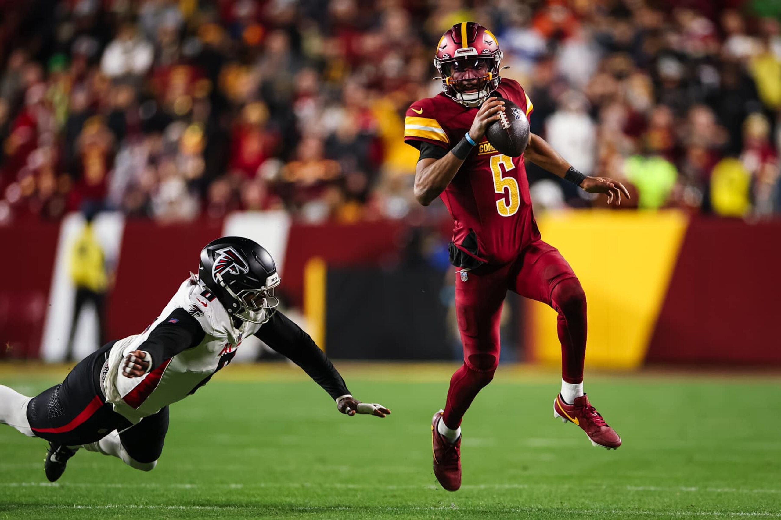 LANDOVER, MD - DECEMBER 29: Jayden Daniels #5 of the Washington Commanders carries the ball against Lorenzo Carter #0 of the Atlanta Falcons during the second half of the game at Northwest Stadium on December 29, 2024 in Landover, Maryland. (Photo by Scott Taetsch/Getty Images) LANDOVER, MD - DECEMBER 29: Jayden Daniels #5 of the Washington Commanders carries the ball against Lorenzo Carter #0 of the Atlanta Falcons during the second half of the game at Northwest Stadium on December 29, 2024 in Landover, Maryland. (Photo by Scott Taetsch/Getty Images)