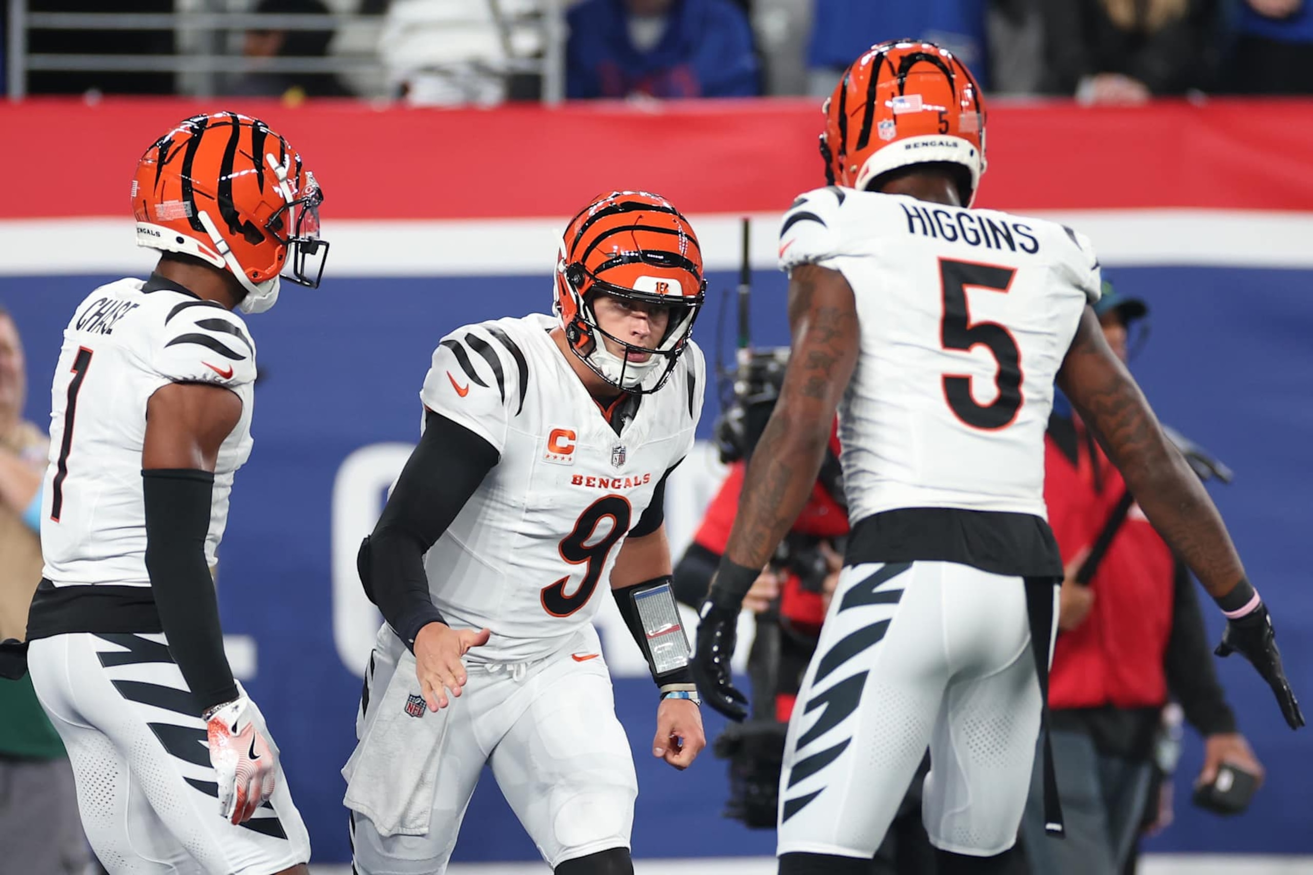 EAST RUTHERFORD, NEW JERSEY - OCTOBER 13: Joe Burrow #9 of the Cincinnati Bengals celebrates a touchdown with Ja'Marr Chase #1 and Tee Higgins #5 during the first half against the New York Giants at MetLife Stadium on October 13, 2024 in East Rutherford, New Jersey. (Photo by Sarah Stier/Getty Images) EAST RUTHERFORD, NEW JERSEY - OCTOBER 13: Joe Burrow #9 of the Cincinnati Bengals celebrates a touchdown with Ja'Marr Chase #1 and Tee Higgins #5 during the first half against the New York Giants at MetLife Stadium on October 13, 2024 in East Rutherford, New Jersey. (Photo by Sarah Stier/Getty Images)