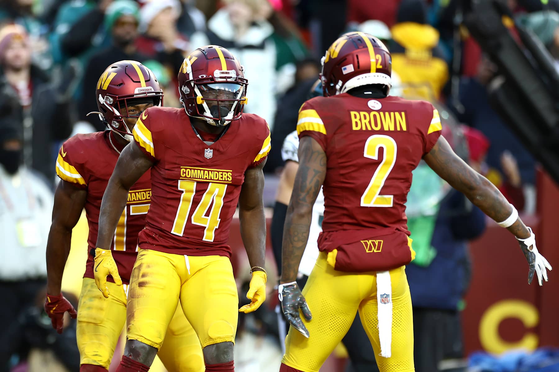 LANDOVER, MARYLAND - DECEMBER 22:  Olamide Zaccheaus #14 of the Washington Commanders is congratulated by Terry McLaurin #17 and Dyami Brown #2 after scoring a touchdown reception against the Philadelphia Eagles during the fourth quarter at Northwest Stadium on December 22, 2024 in Landover, Maryland. (Photo by Timothy Nwachukwu/Getty Images)