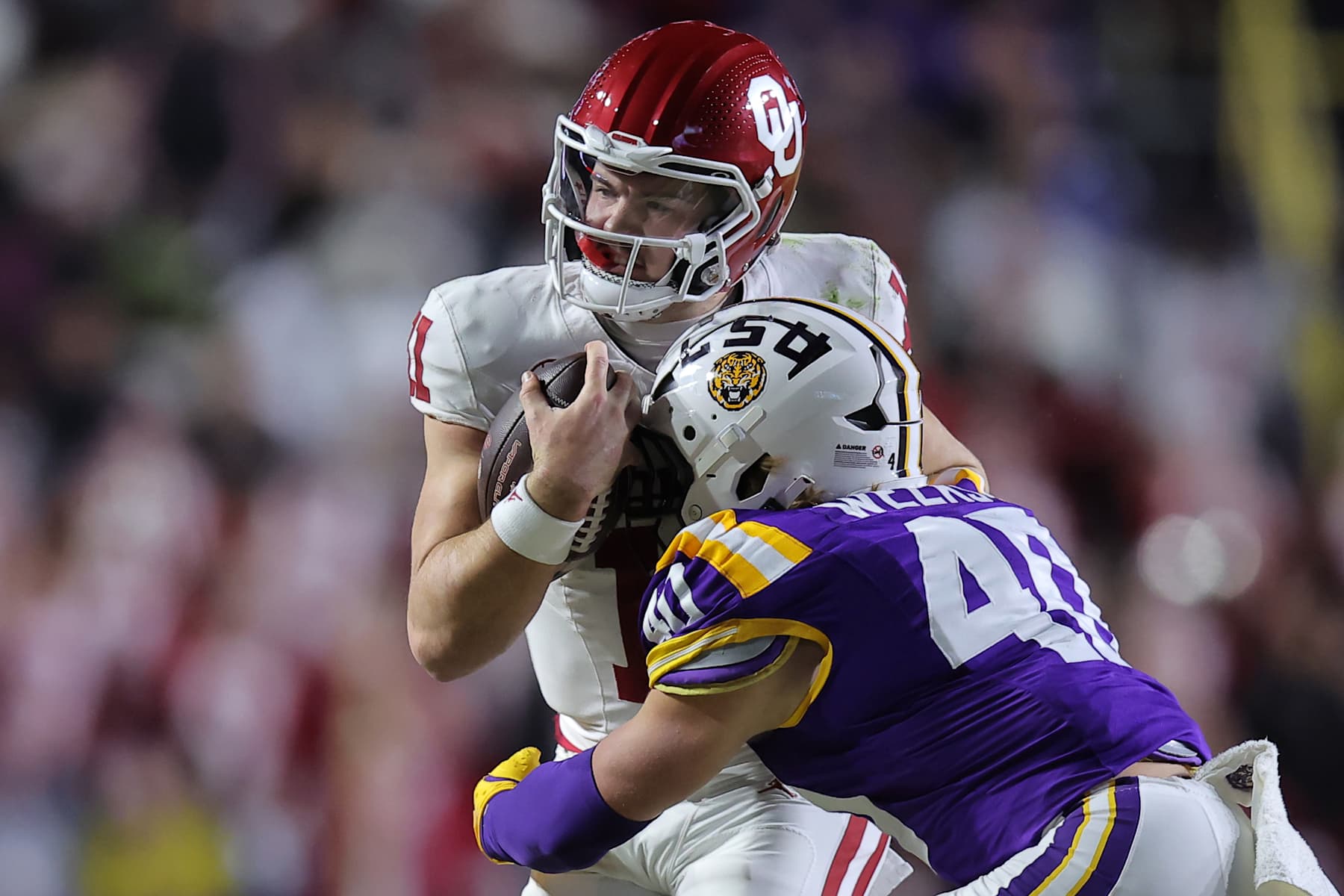 BATON ROUGE, LOUISIANA - NOVEMBER 30: Jackson Arnold #11 of the Oklahoma Sooners is tackled by Whit Weeks #40 of the LSU Tigers during the first half at Tiger Stadium on November 30, 2024 in Baton Rouge, Louisiana. (Photo by Jonathan Bachman/Getty Images)