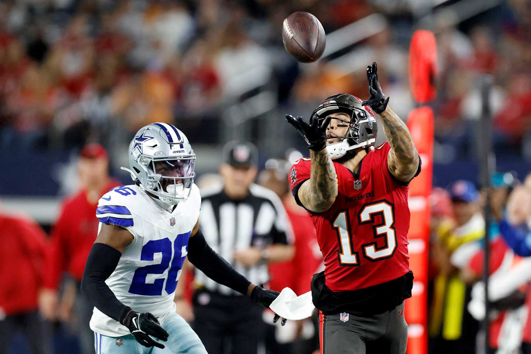 ARLINGTON, TEXAS - DECEMBER 22: Mike Evans #13 of the Tampa Bay Buccaneers catches a pass in front of DaRon Bland #26 of the Dallas Cowboys for a first down during the second quarter at AT&T Stadium on December 22, 2024 in Arlington, Texas. (Photo by Ron Jenkins/Getty Images)