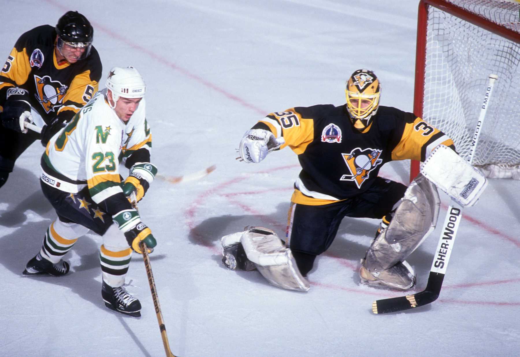 BLOOMINGTON, MN - MAY 21: Brian Bellows #23 of the Minnesota North Stars tries to shoot as he is hooked by Ulf Samuelsson #28 of the Pittsburgh Penguins as goalie Tom Barrasso #35 of the Penguins defends the net during Game 4 of the 1991 Stanley Cup Finals on May 21, 1991 at the Met Center in Bloomington, Minnesota. (Photo by B Bennett/Getty Images) 