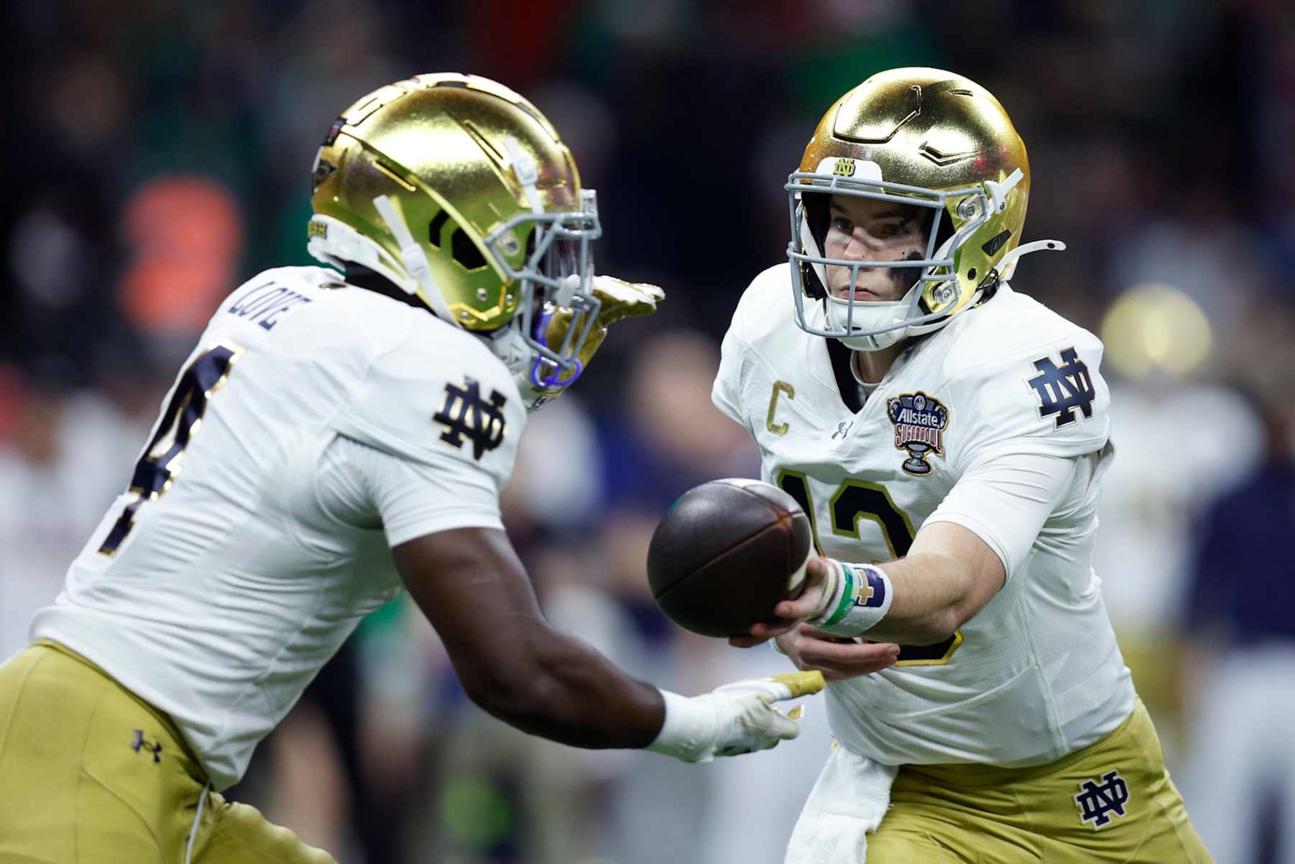 NEW ORLEANS, LOUISIANA - JANUARY 02: Riley Leonard #13 of the Notre Dame Fighting Irish hands off to Jeremiyah Love #4 during the first quarter against the Georgia Bulldogs during the 91st Allstate Sugar Bowl at Caesars Superdome on January 02, 2025 in New Orleans, Louisiana. (Photo by Sean Gardner/Getty Images)