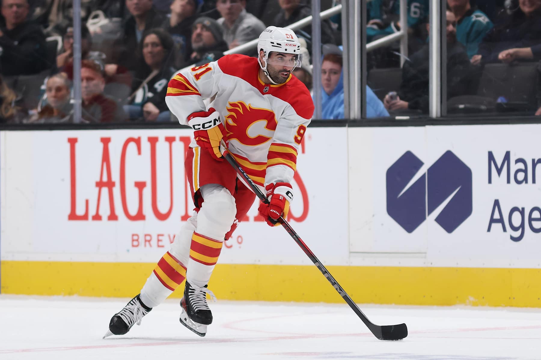 SAN JOSE, CALIFORNIA - DECEMBER 28: Nazem Kadri #91 of the Calgary Flames skates with the puck during the third period of the NHL game at SAP Center on December 28, 2024 in San Jose, California. The Flames defeated the Sharks 3-1.  (Photo by Christian Petersen/Getty Images)