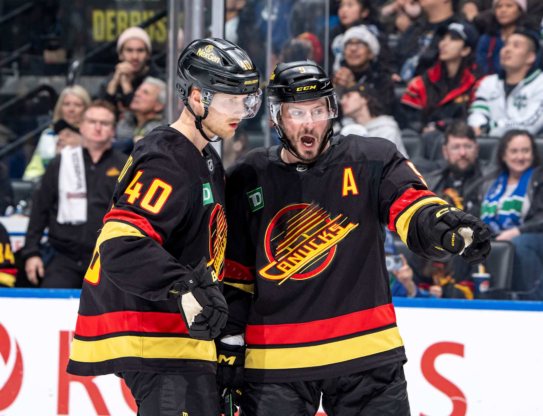 VANCOUVER, CANADA - DECEMBER 23: Elias Pettersson #40 and J.T. Miller #9 of the Vancouver Canucks discuss game play during the second period of their NHL game against the San Jose Sharks at Rogers Arena on December 23, 2024 in Vancouver, British Columbia, Canada.  (Photo by Jeff Vinnick/NHLI via Getty Images)