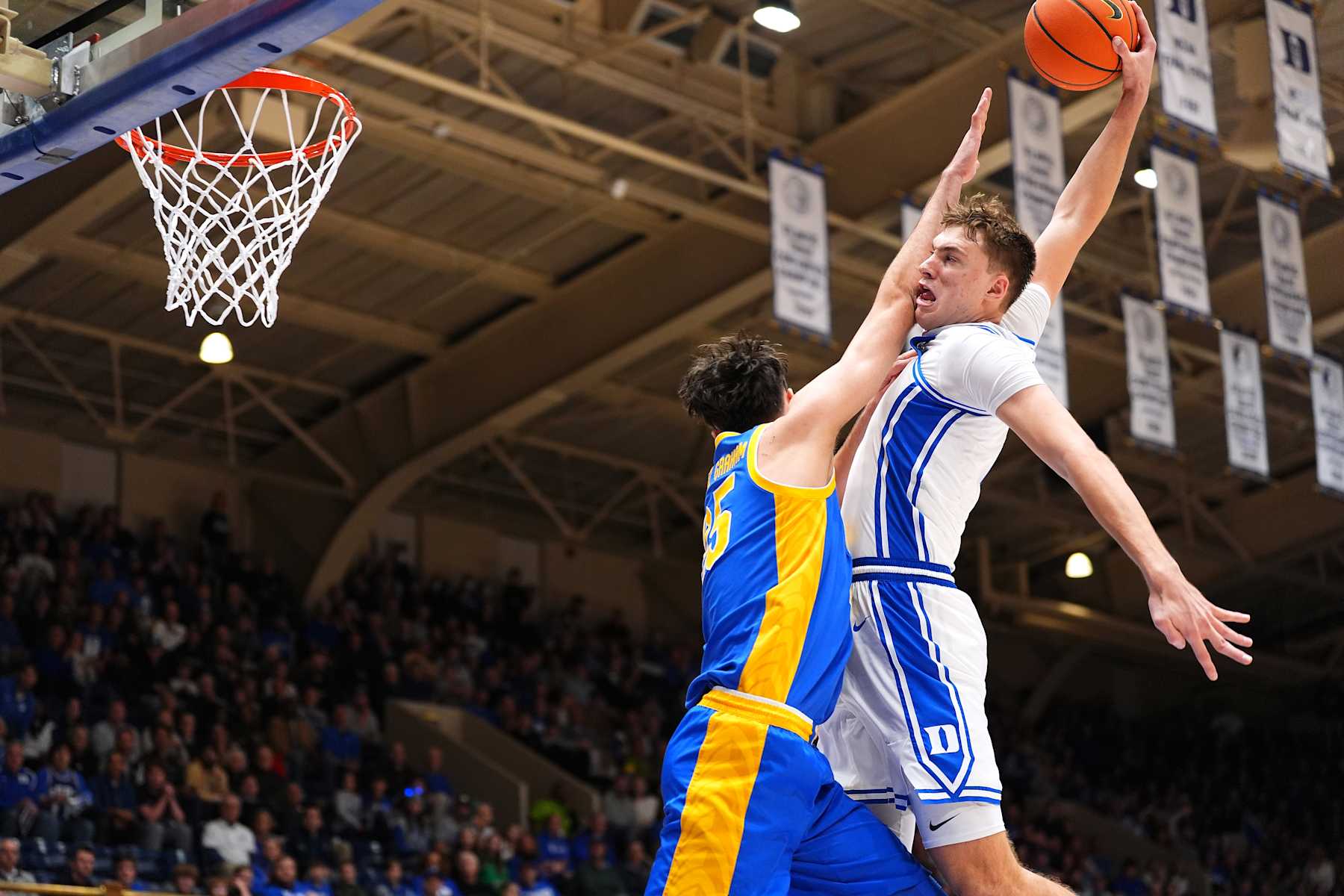 DURHAM, NORTH CAROLINA - JANUARY 07: Cooper Flagg #2 of the Duke Blue Devils dunks over Guillermo Diaz Graham #25 of the Pittsburgh Panthers during the second half of the game at Cameron Indoor Stadium on January 07, 2025 in Durham, North Carolina. (Photo by Grant Halverson/Getty Images)