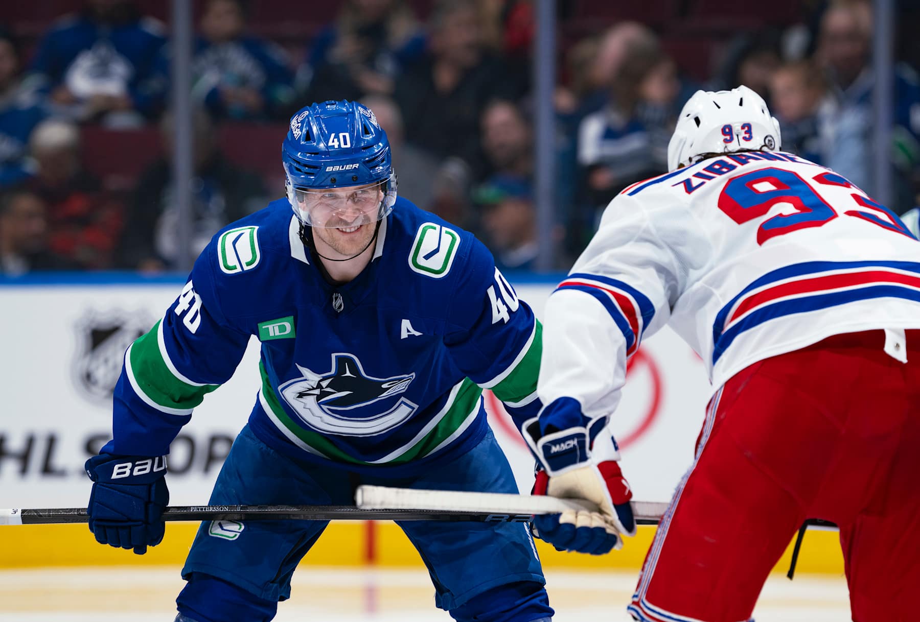VANCOUVER, CANADA - NOVEMBER 19: Elias Pettersson #40 of the Vancouver Canucks and Mika Zibanejad #93 of the New York Rangers line up for a face off during their NHL game at Rogers Arena on November 19, 2024 in Vancouver, British Columbia, Canada.  (Photo by Jeff Vinnick/NHLI via Getty Images)