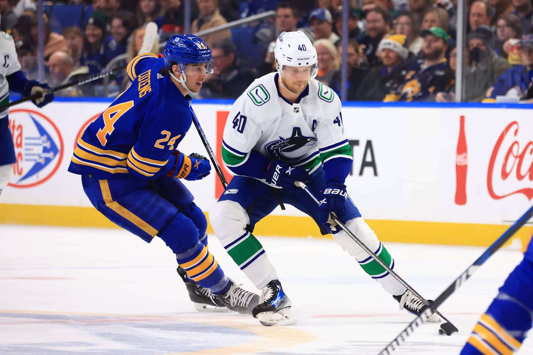 BUFFALO, NEW YORK - JANUARY 13: Elias Pettersson #40 of the Vancouver Canucks controls the puck against Dylan Cozens #24 of the Buffalo Sabres during an NHL game on January 13, 2024 at KeyBank Center in Buffalo, New York. (Photo by Bill Wippert/NHLI via Getty Images)