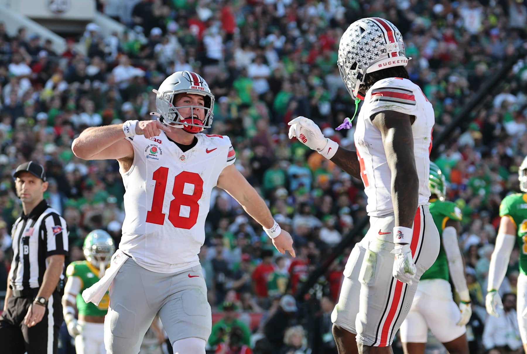 PASADENA, CALIFORNIA - JANUARY 1:  Will Howard #18 of the Ohio State Buckeyes celebrates with Jeremiah Smith #4 of the Ohio State Buckeyes after a touchdown during the first half against the Oregon Ducks at Rose Bowl Stadium on January 1, 2025 in Pasadena, California. (Photo by CFP/Getty Images)