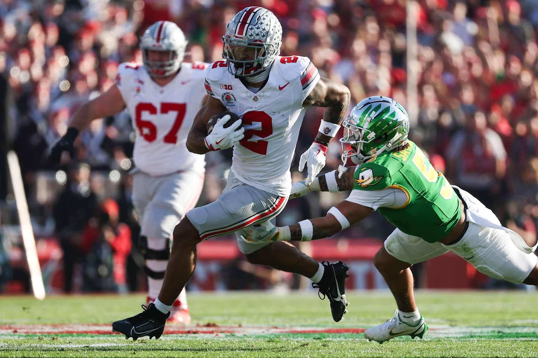 PASADENA, CALIFORNIA - JANUARY 1: Emeka Egbuka #2 of the Ohio State Buckeyes runs the ball against Kobe Savage (5) of the Oregon Ducks during the first half at Rose Bowl Stadium on January 1, 2025 in Pasadena, California. (Photo by CFP/Getty Images)
