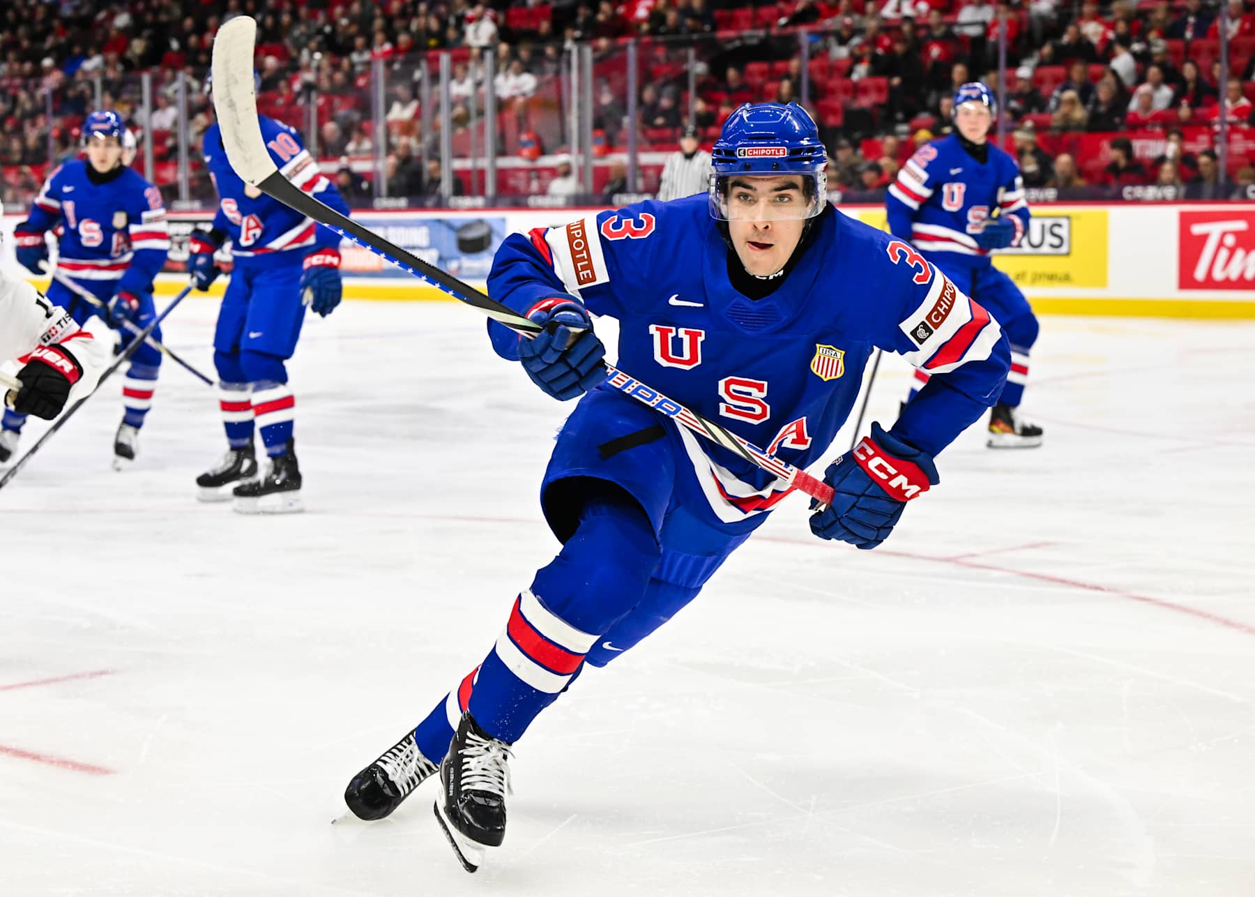 OTTAWA, CANADA - JANUARY 02:  Logan Hensler #3 of Team USA skates in the second period against Team Switzerland of the quarterfinals match during the 2025 IIHF World Junior Championship at Canadian Tire Centre on January 2, 2025 in Ottawa, Ontario, Canada.  Team USA defeated Team Switzerland 7-2.  (Photo by Minas Panagiotakis/Getty Images)