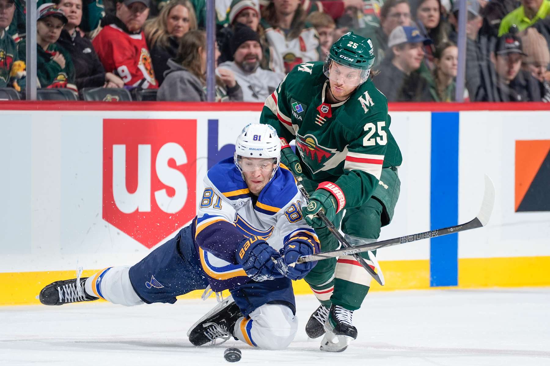 SAINT PAUL, MN - JANUARY 7: Dylan Holloway #81 of the St. Louis Blues and Jonas Brodin #25 of the Minnesota Wild battle for the puck during the game at the Xcel Energy Center on January 7, 2025 in Saint Paul, Minnesota. (Photo by Bruce Kluckhohn/NHLI via Getty Images)