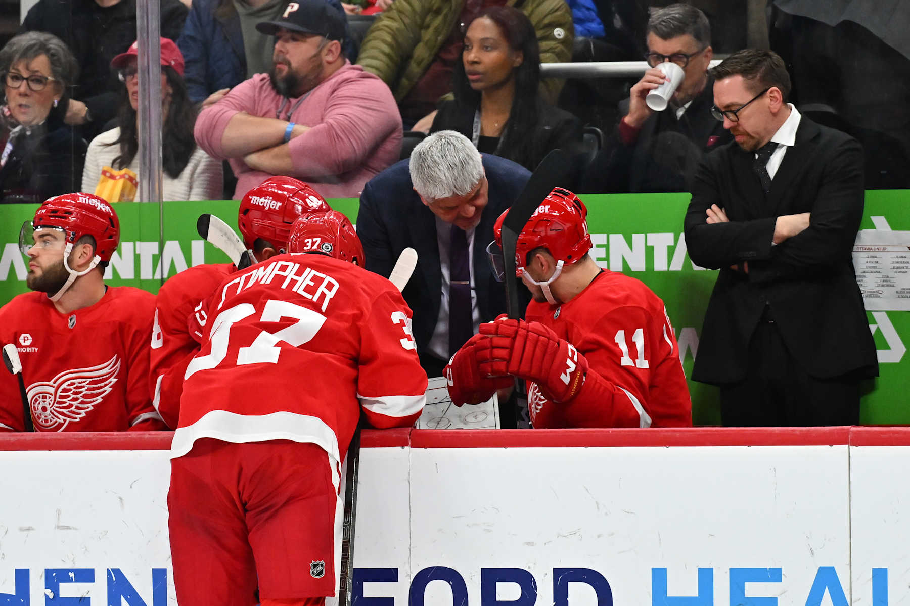 DETROIT, MI - JANUARY 07: Detroit Red Wings head coach Todd McLellan talks to Detroit Red Wings left wing J.T. Compher (37) and Detroit Red Wings right wing Vladimir Tarasenko (11) during a break during the game between the Detroit Red Wings and the Ottawa Senators Tuesday January 7, 2025 at Little Caesars Arena in Detroit, MI. (Photo by Steven King/Icon Sportswire via Getty Images)