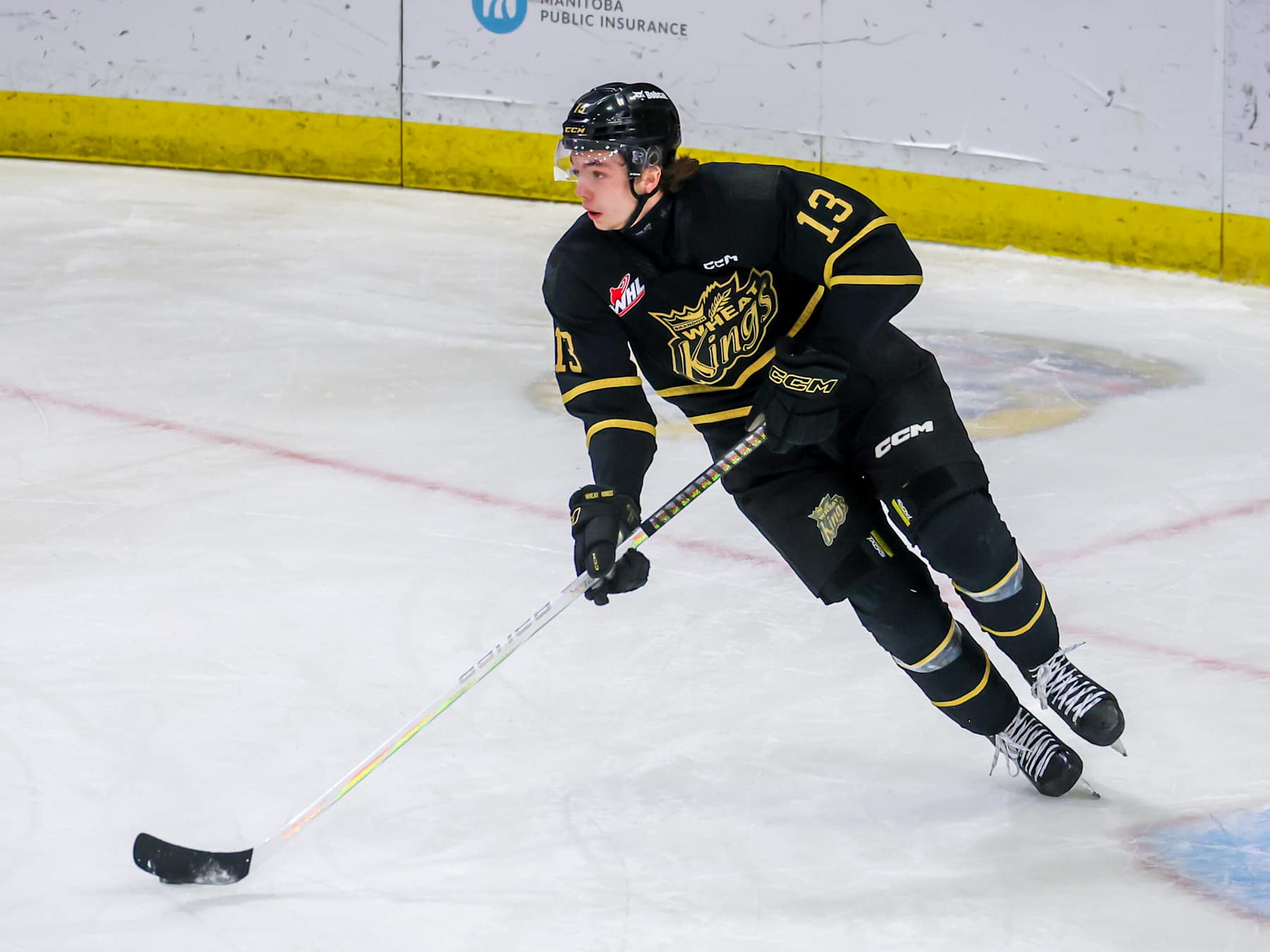 BRANDON, CANADA - APRIL 03: Roger McQueen #13 of the Brandon Wheat Kings plays the puck during first period action against the Moose Jaw Warriors in Game Three of the First Round of the 2024 WHL Playoffs at Westoba Place on April 03, 2024 in Brandon, Manitoba, Canada. (Photo by Jonathan Kozub/Getty Images)