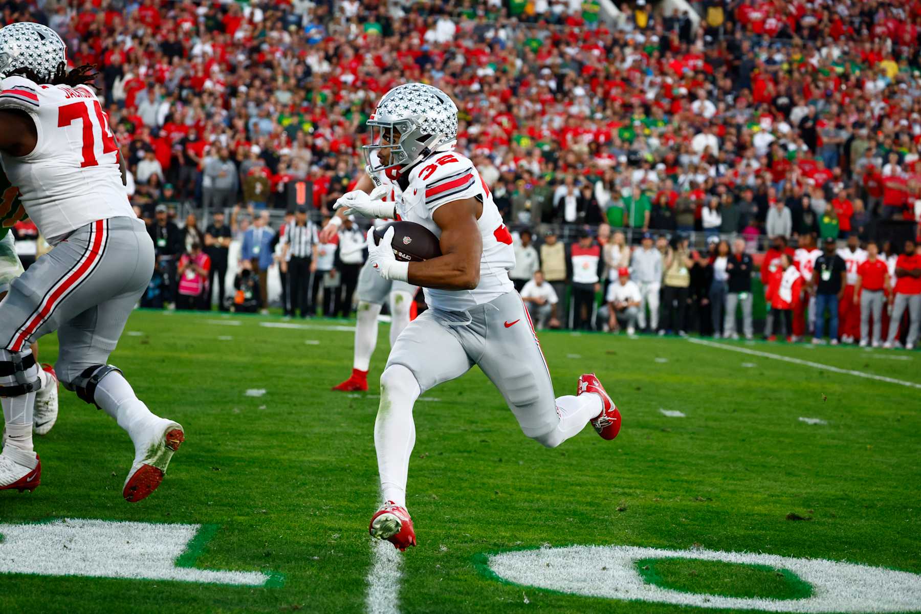 PASADENA, CA - JANUARY 01: Running Back TreVeyon Henderson #32 of the Ohio State Buckeyes run for 8 yards for a touchdown during the Ohio State Buckeyes versus Oregon Ducks College Football Playoff Quarterfinal at the Rose Bowl Game on January 1, 2025, at the Rose Bowl Stadium in Pasadena, CA. (Photo by Jeff Speer/Icon Sportswire via Getty Images)