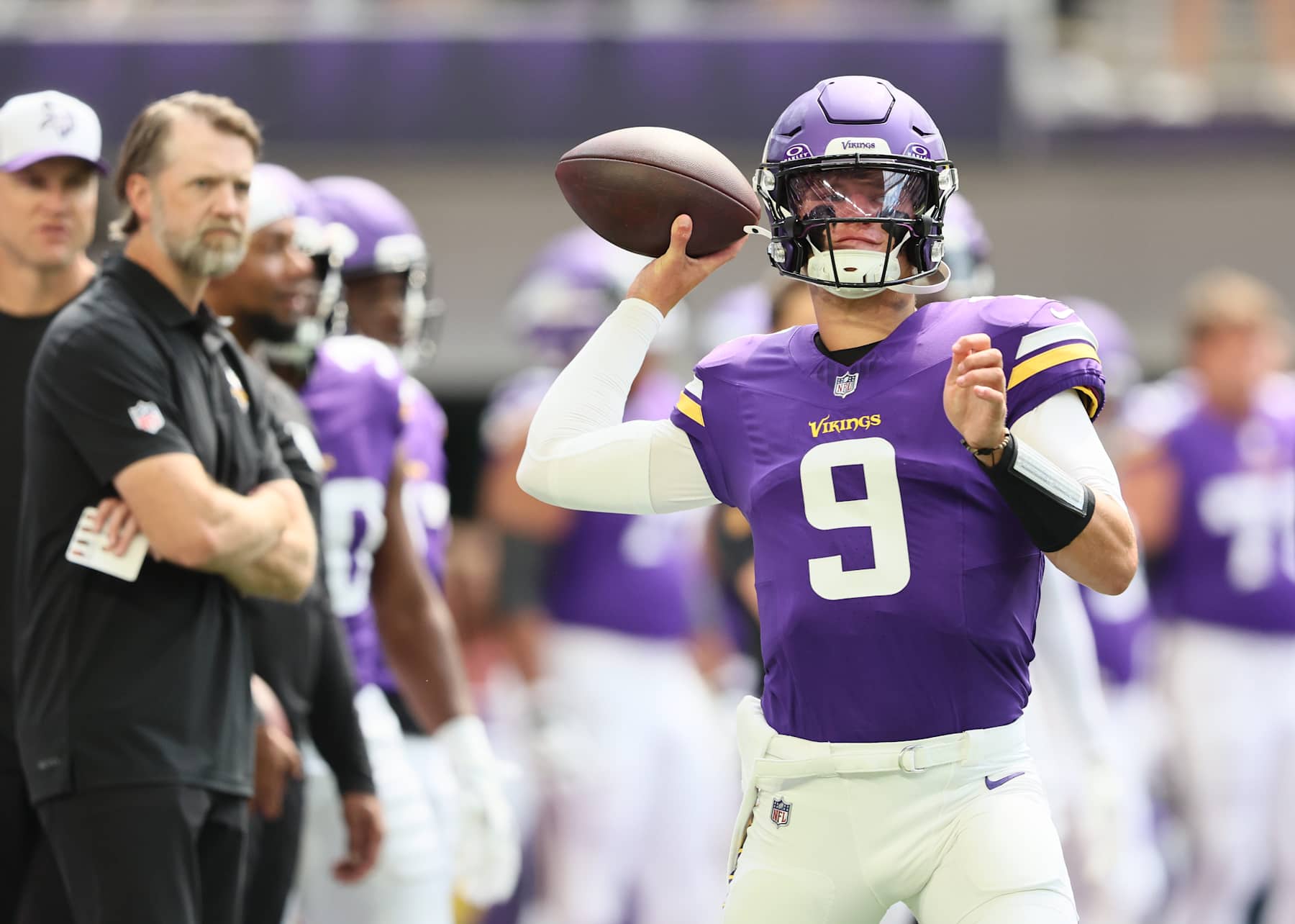 MINNEAPOLIS, MINNESOTA - AUGUST 10: Minnesota Vikings Offensive Coordinator Wes Phillips watches J.J. McCarthy #9 of the Minnesota Vikings warm up before the pre-season game against Las Vegas Raiders at U.S. Bank Stadium on August 10, 2024 in Minneapolis, Minnesota. J.J. McCarthys season was cut short due to a knee injury in the preseason game. (Photo by Adam Bettcher/Getty Images)