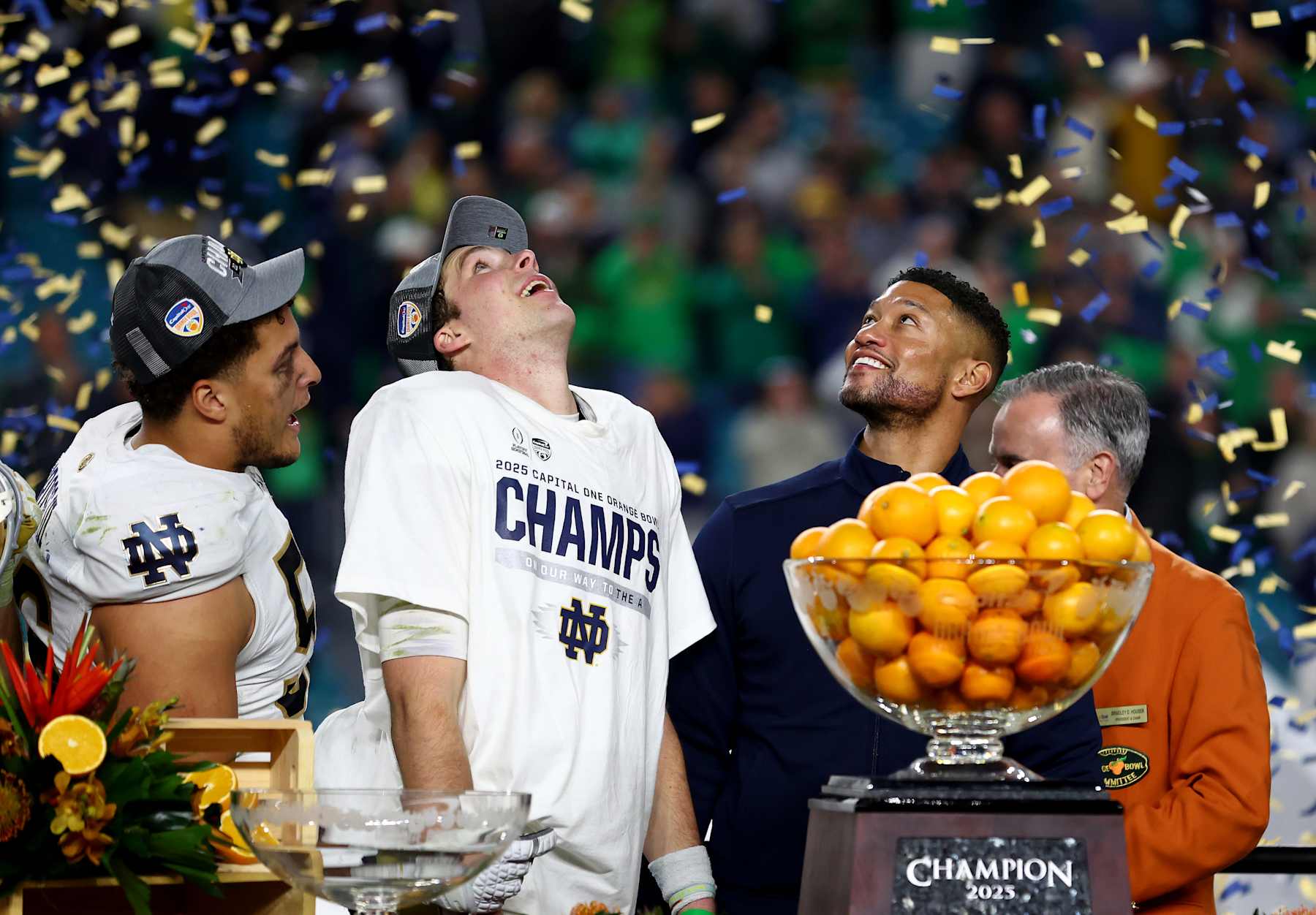 MIAMI GARDENS, FLORIDA - JANUARY 09: Riley Leonard #13 of the Notre Dame Fighting Irish (C) and head coach Marcus Freeman (R) celebrate after defeating the Penn State Nittany Lions 27-24 in the Capital One Orange Bowl at Hard Rock Stadium on January 09, 2025 in Miami Gardens, Florida. (Photo by Megan Briggs/Getty Images)