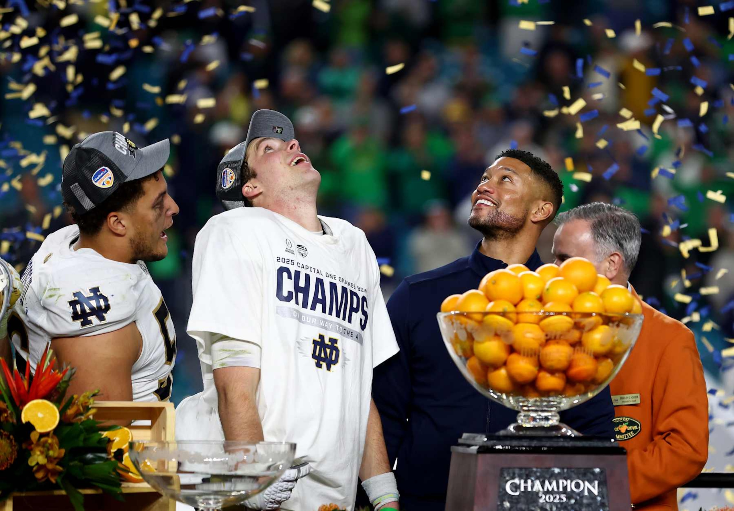 MIAMI GARDENS, FLORIDA - JANUARY 09: Riley Leonard #13 of the Notre Dame Fighting Irish (C) and head coach Marcus Freeman (R) celebrate after defeating the Penn State Nittany Lions 27-24 in the Capital One Orange Bowl at Hard Rock Stadium on January 09, 2025 in Miami Gardens, Florida. (Photo by Megan Briggs/Getty Images)