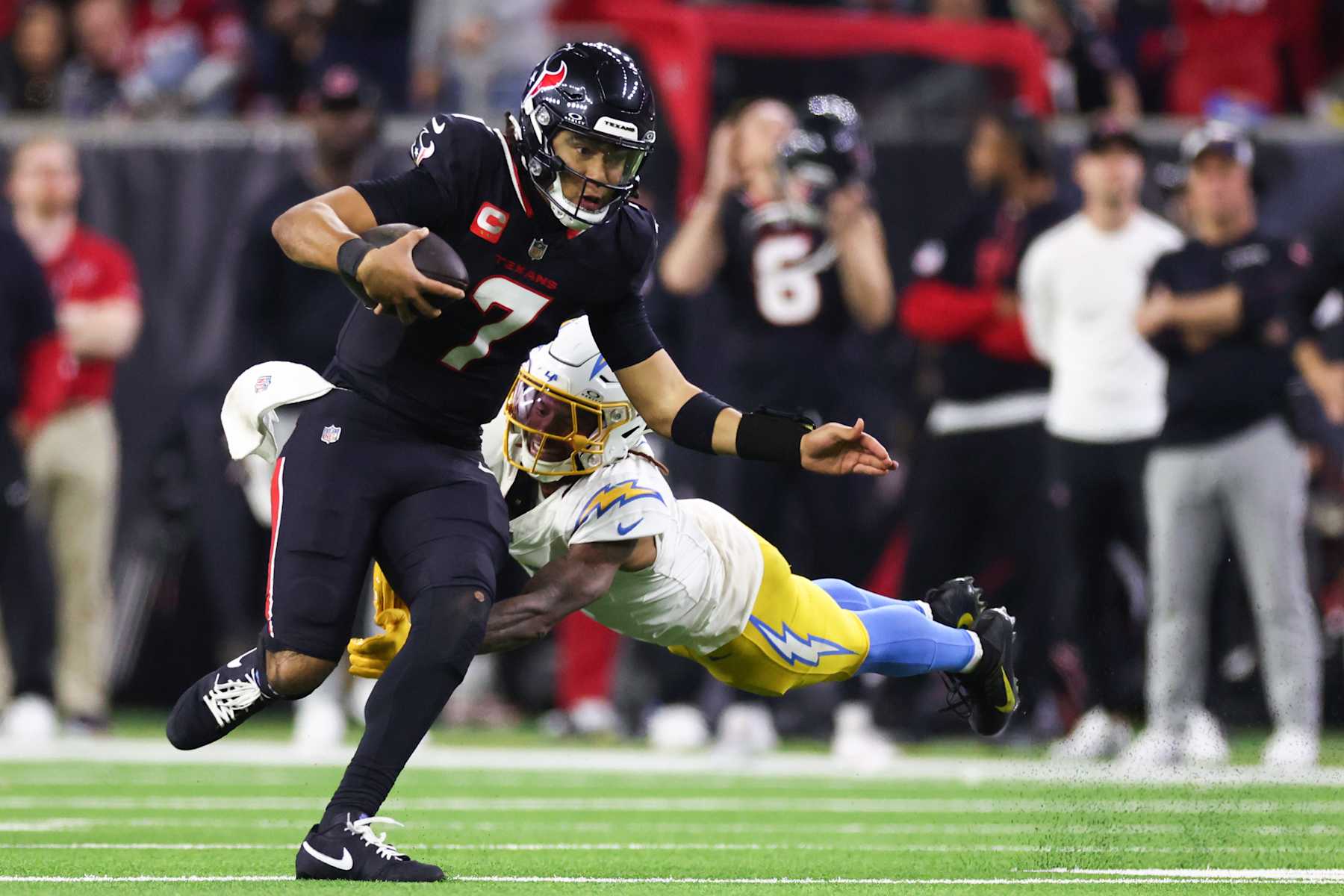 HOUSTON, TEXAS - JANUARY 11: C.J. Stroud #7 of the Houston Texans carries the ball against the Los Angeles Chargers in the fourth quarter during the AFC Wild Card Playoffs at NRG Stadium on January 11, 2025 in Houston, Texas. (Photo by Tim Warner/Getty Images)