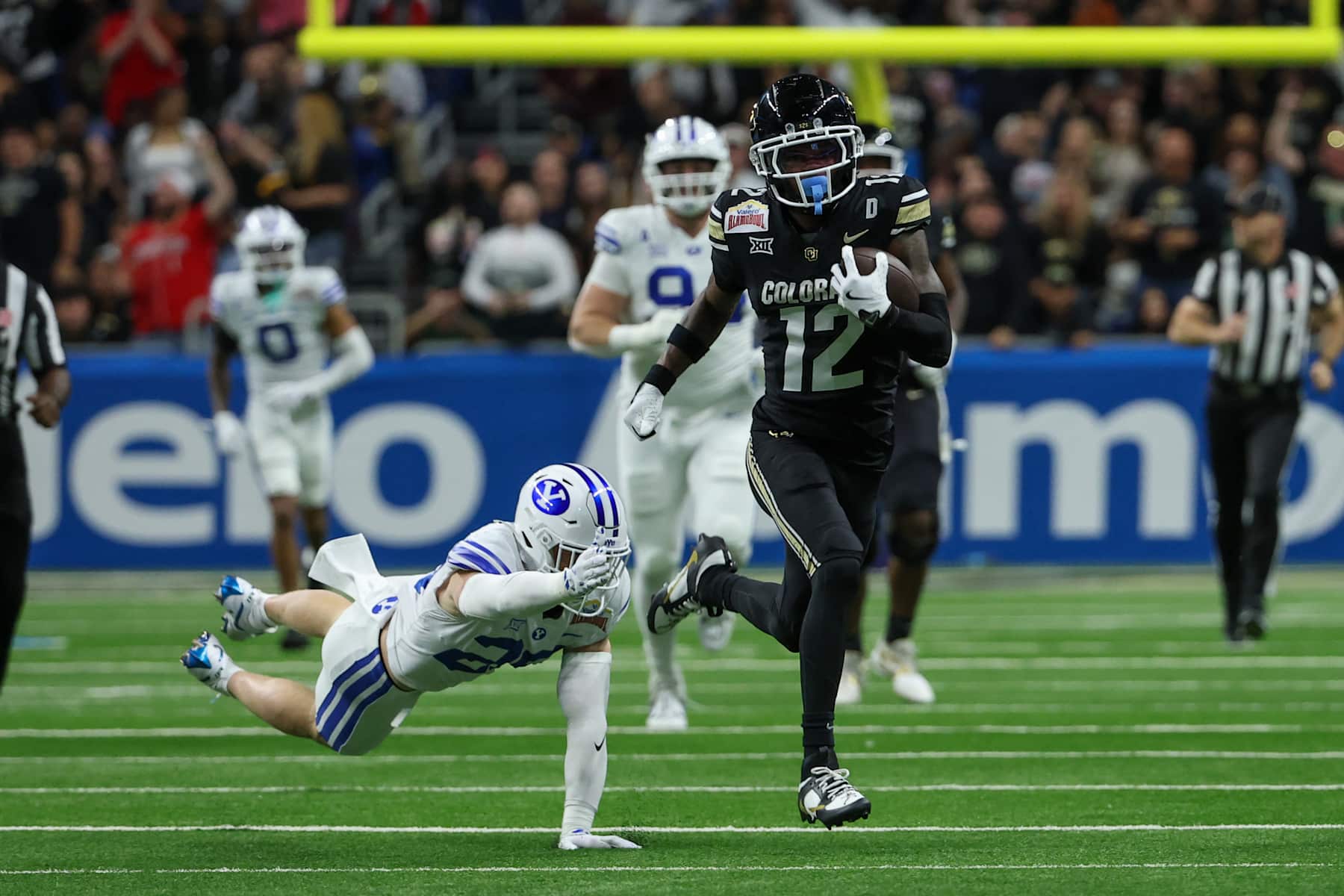SAN ANTONIO, TX - DECEMBER 28: Colorado Buffaloes wide receiver Travis Hunter (12) avoids a tackle by Brigham Young Cougars safety Tanner Wall (28) after a reception during the football game between BYU Cougars and Colorado Buffalos on December 28, 2024, at the Alamodome in San Antonio, Texas. (Photo by David Buono/Icon Sportswire via Getty Images)