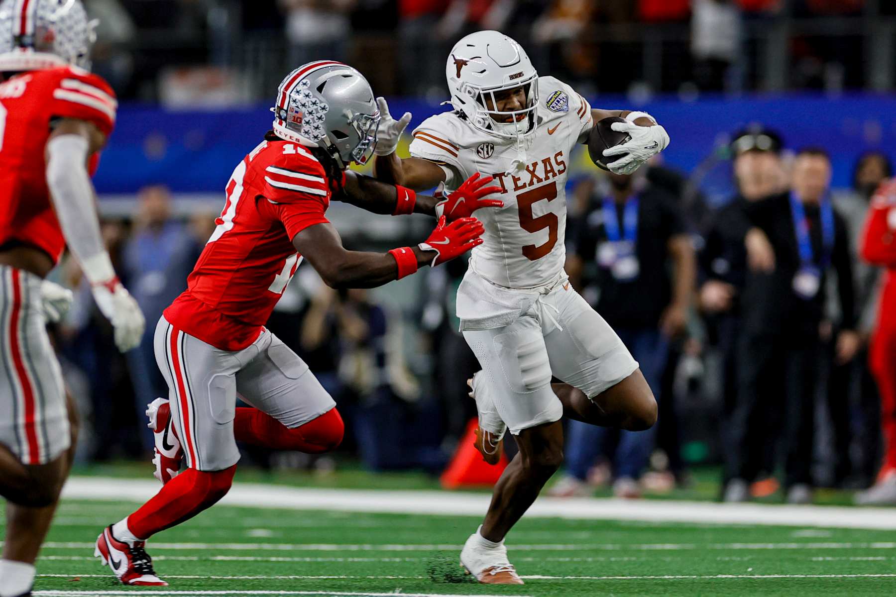 Texas' Ryan Wingo stiff-arms Ohio State's Denzel Burke