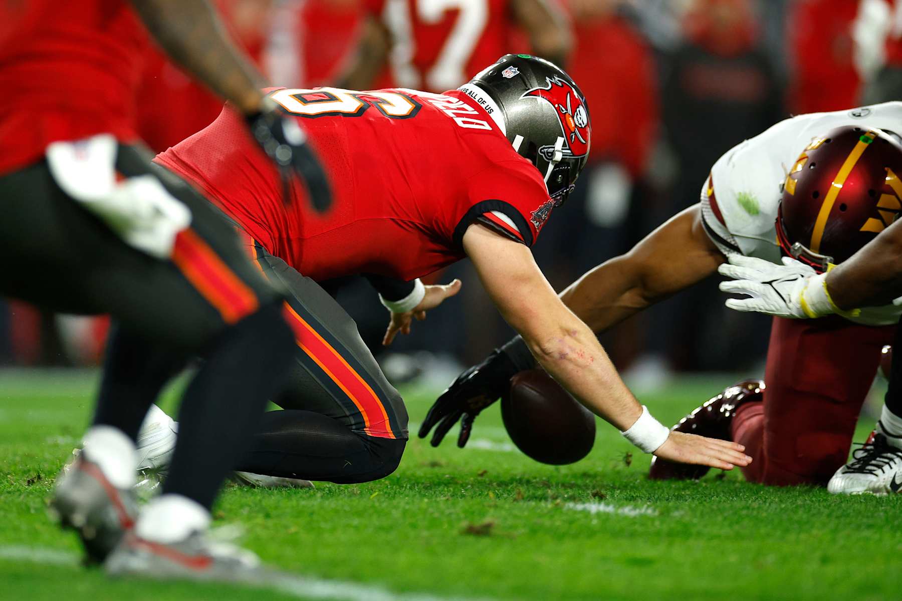 TAMPA, FLORIDA - JANUARY 12: Baker Mayfield #6 of the Tampa Bay Buccaneers fumbles against Bobby Wagner #54 of the Washington Commanders during the fourth quarter in the NFC Wild Card Playoff at Raymond James Stadium on January 12, 2025 in Tampa, Florida. (Photo by Mike Ehrmann/Getty Images)