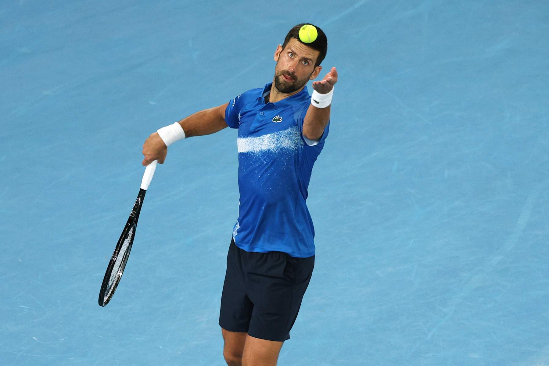 Serbia's Novak Djokovic serves against USA's Nishesh Basavareddy during their men's singles match on day two of the Australian Open tennis tournament in Melbourne on January 13, 2025. (Photo by Adrian DENNIS / AFP) / -- IMAGE RESTRICTED TO EDITORIAL USE - STRICTLY NO COMMERCIAL USE -- (Photo by ADRIAN DENNIS/AFP via Getty Images)