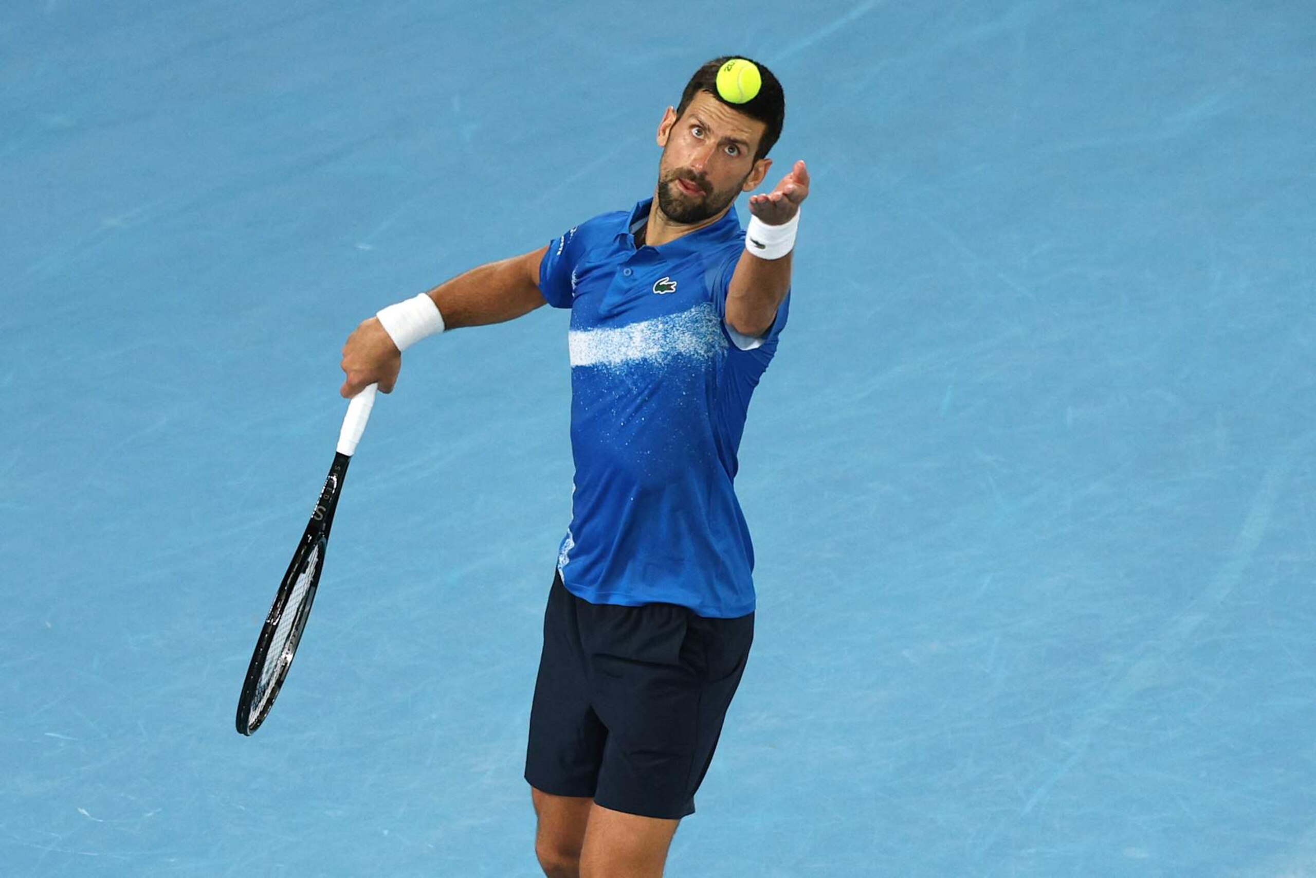 Serbia's Novak Djokovic serves against USA's Nishesh Basavareddy during their men's singles match on day two of the Australian Open tennis tournament in Melbourne on January 13, 2025. (Photo by Adrian DENNIS / AFP) / -- IMAGE RESTRICTED TO EDITORIAL USE - STRICTLY NO COMMERCIAL USE -- (Photo by ADRIAN DENNIS/AFP via Getty Images) Serbia's Novak Djokovic serves against USA's Nishesh Basavareddy during their men's singles match on day two of the Australian Open tennis tournament in Melbourne on January 13, 2025. (Photo by Adrian DENNIS / AFP) / -- IMAGE RESTRICTED TO EDITORIAL USE - STRICTLY NO COMMERCIAL USE -- (Photo by ADRIAN DENNIS/AFP via Getty Images)