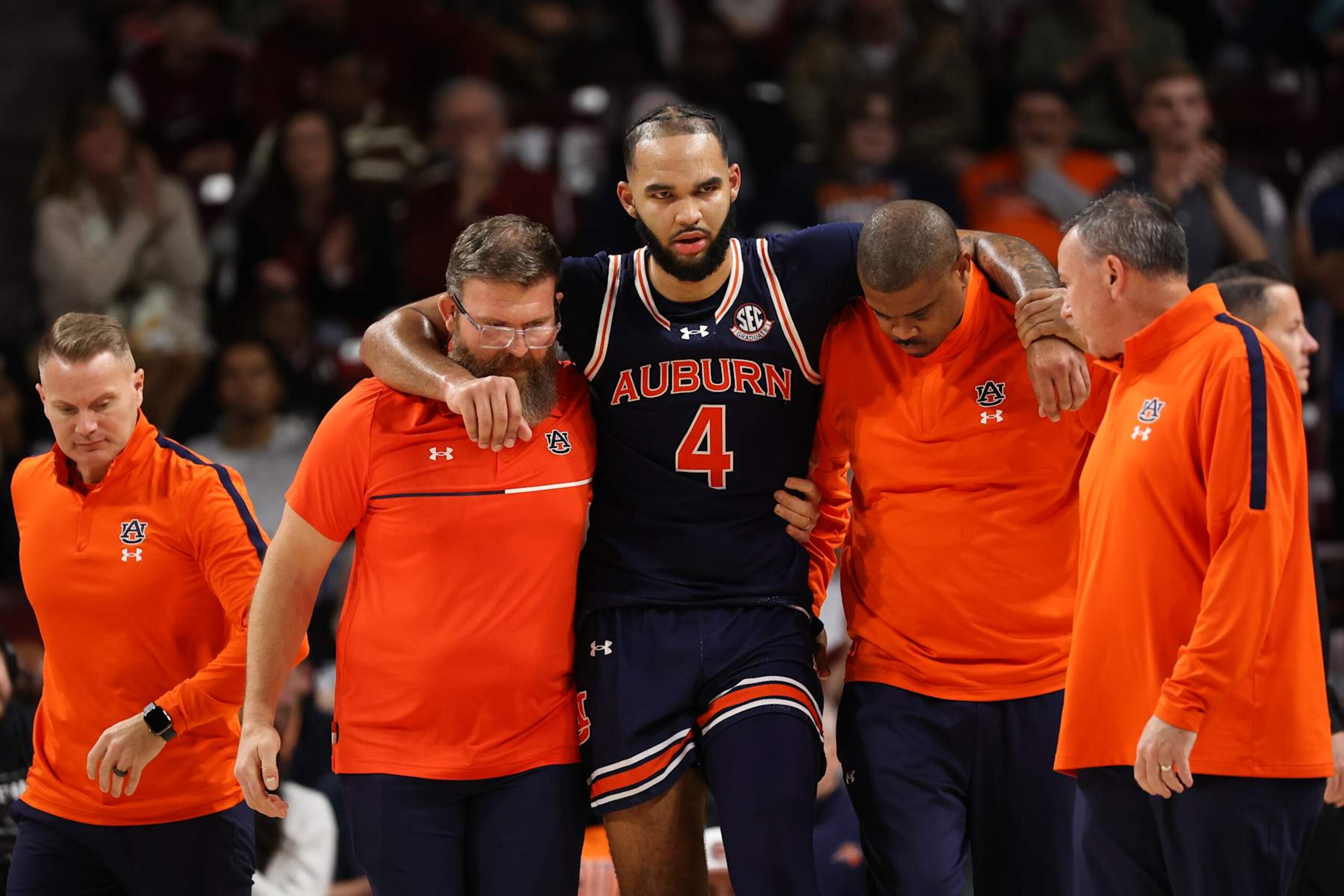 COLUMBIA, SOUTH CAROLINA - JANUARY 11: Johni Broome #4 of the Auburn Tigers is carried off the court by Director of Sports Performance Damon Davis of the Auburn Tigers and an assistant coach during the second half against the South Carolina Gamecocks at Colonial Life Arena on January 11, 2025 in Columbia, South Carolina.  (Photo by Isaiah Vazquez/Getty Images)