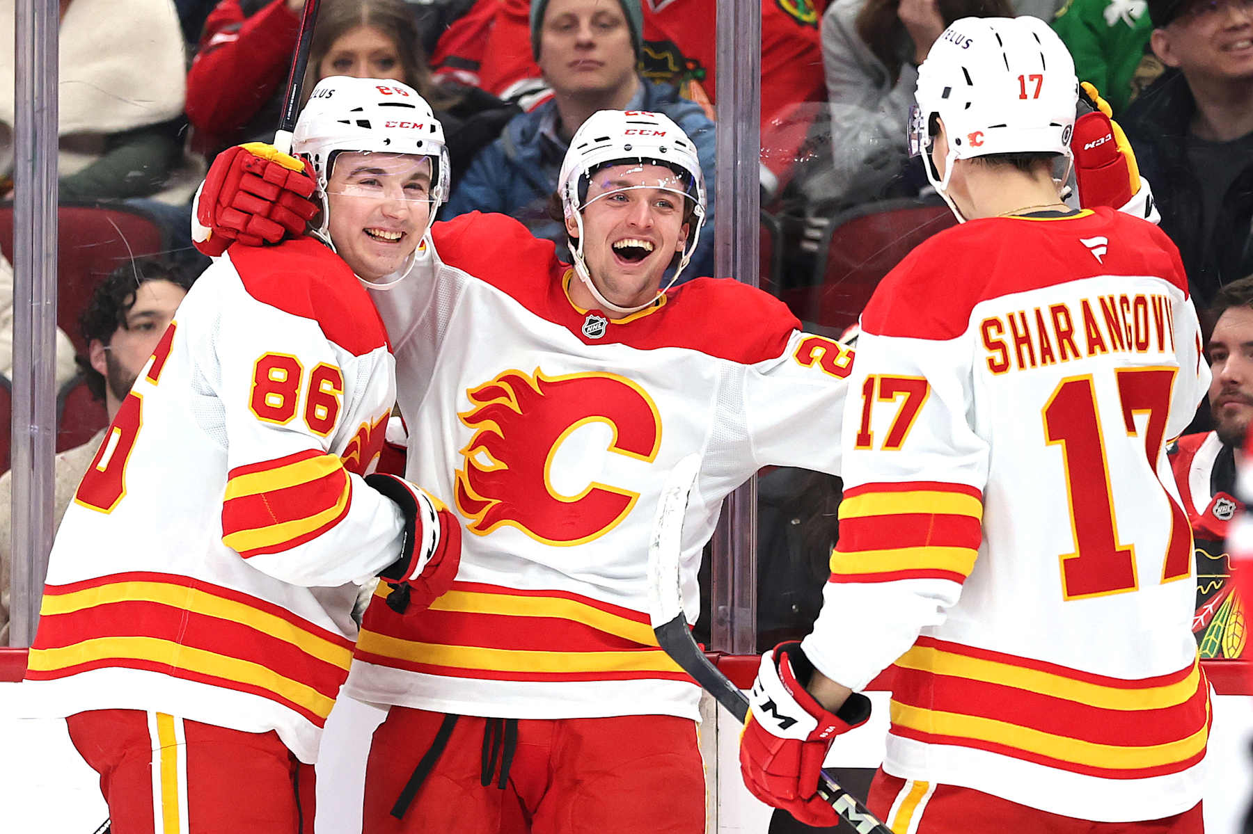 CHICAGO, ILLINOIS - JANUARY 13: Jakob Pelletier #22 of the Calgary Flames celebrates with Rory Kerins #86 and Yegor Sharangovich #17 after scoring a goal against the Chicago Blackhawks during the first period at the United Center on January 13, 2025 in Chicago, Illinois. (Photo by Michael Reaves/Getty Images)