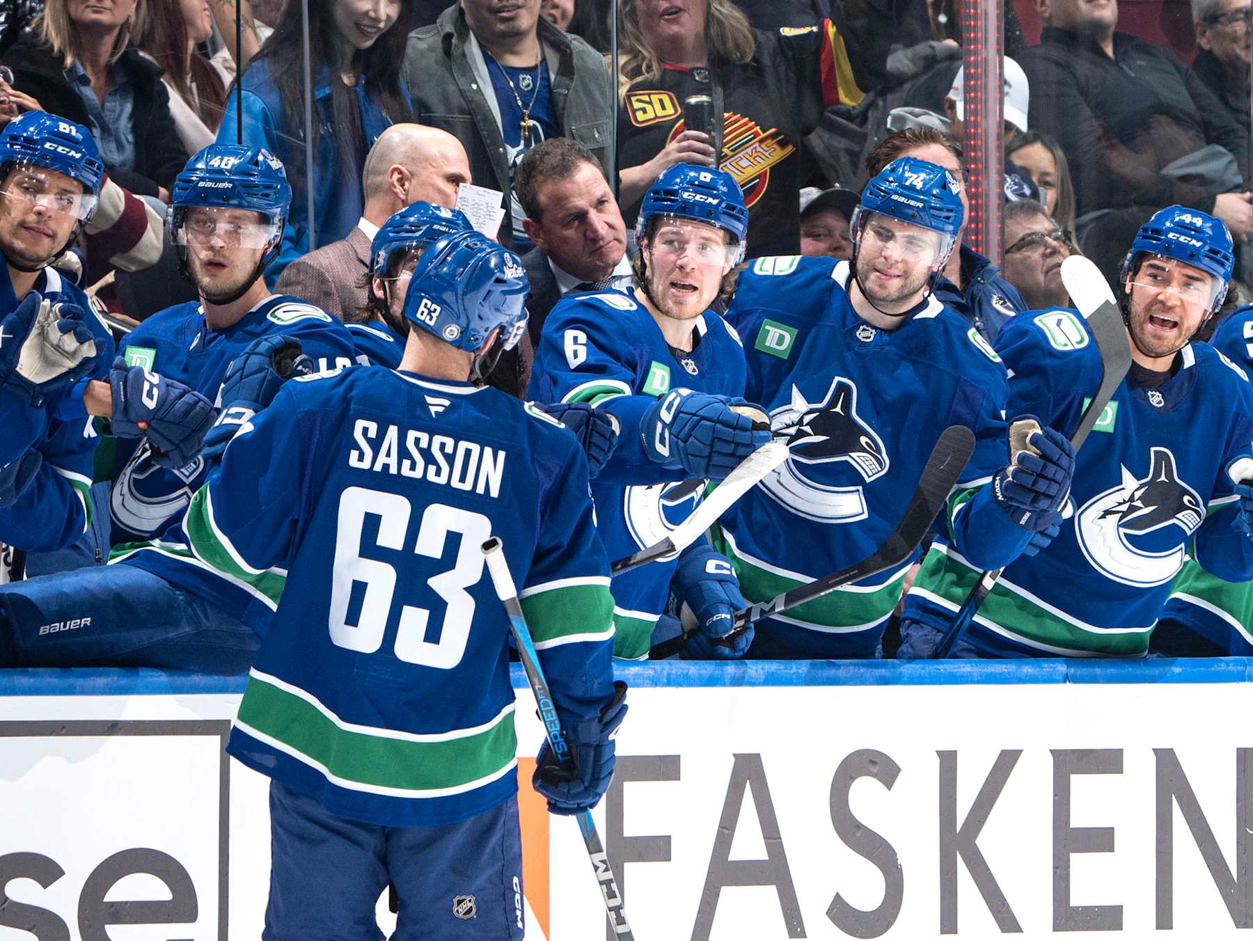 VANCOUVER, CANADA - DECEMBER 14: Max Sasson #63 of the Vancouver Canucks celebrates his goal with teammates during the third period of their NHL game against the Boston Bruins at Rogers Arena on December 14, 2024 in Vancouver, British Columbia, Canada.  (Photo by Jeff Vinnick/NHLI via Getty Images)