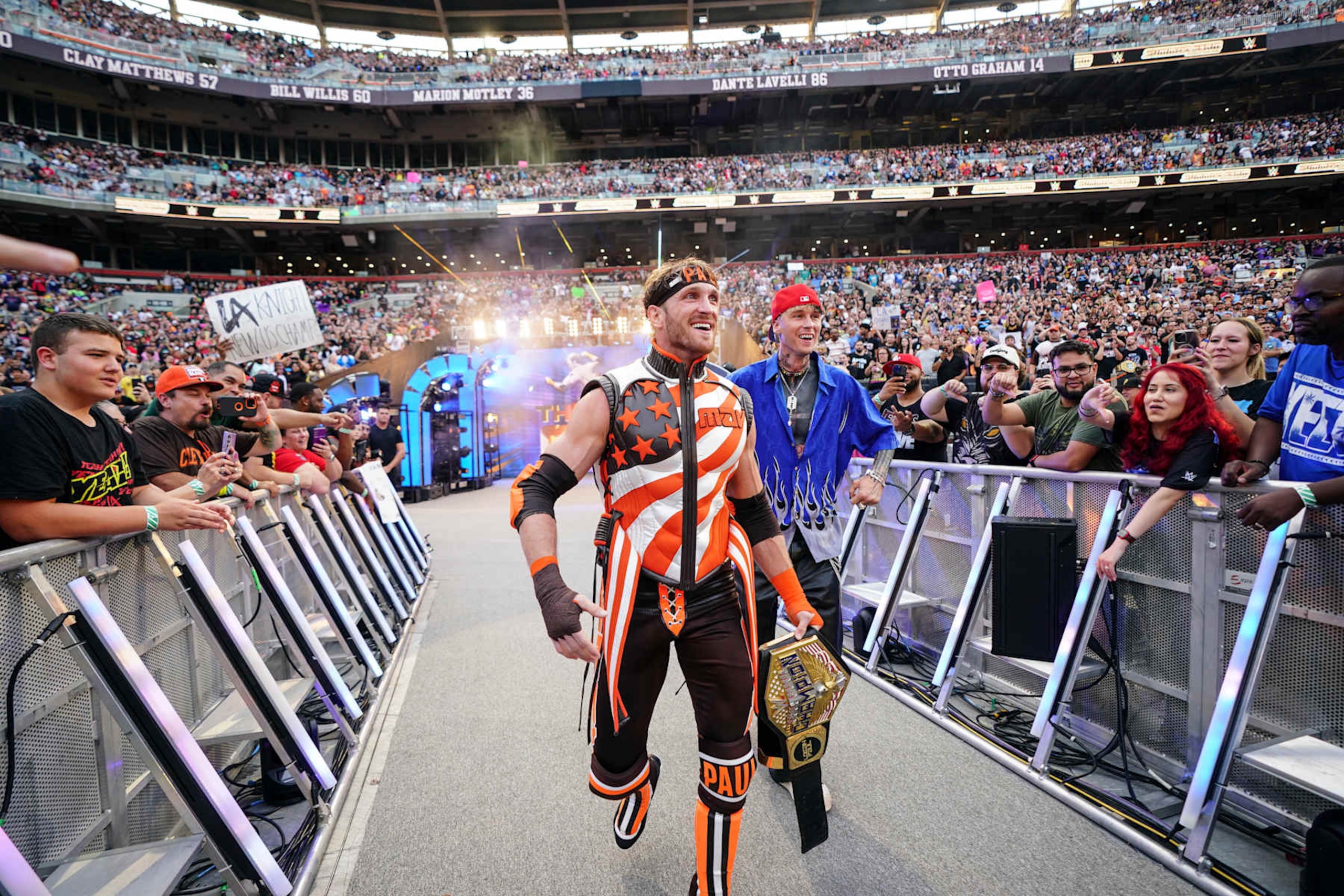 CLEVELAND, OHIO - AUGUST 03: Logan Paul accompanied by Machine Gun Kelly make their way to the ring during SummerSlam at Cleveland Browns Stadium on August 3, 2024 in Cleveland, Ohio. (Photo by WWE/Getty Images) CLEVELAND, OHIO - AUGUST 03: Logan Paul accompanied by Machine Gun Kelly make their way to the ring during SummerSlam at Cleveland Browns Stadium on August 3, 2024 in Cleveland, Ohio. (Photo by WWE/Getty Images)