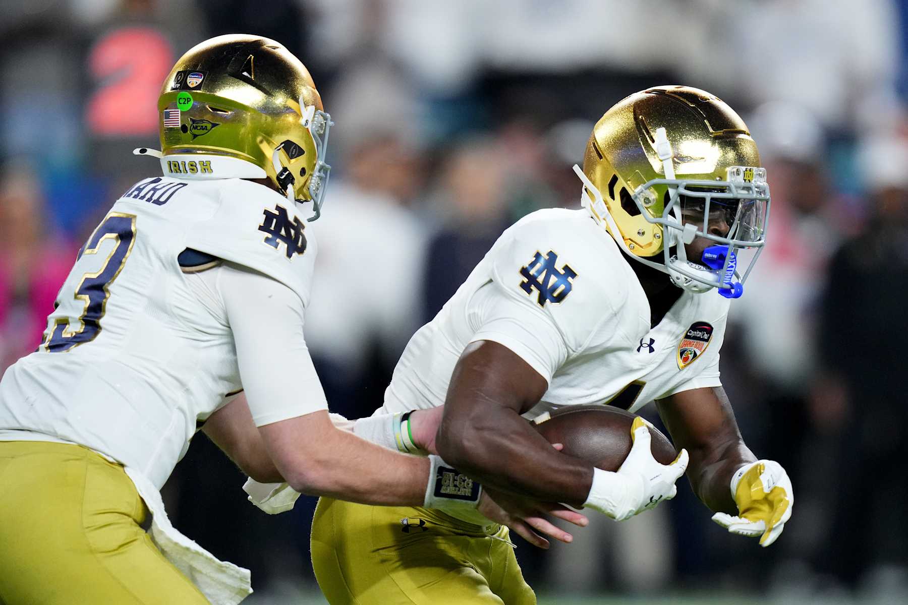MIAMI GARDENS, FLORIDA - JANUARY 09: Riley Leonard #13 of the Notre Dame Fighting Irish hands the ball to Jeremiyah Love #4 during the first quarter against the Penn State Nittany Lions in the Capital One Orange Bowl at Hard Rock Stadium on January 09, 2025 in Miami Gardens, Florida. (Photo by Rich Storry/Getty Images)