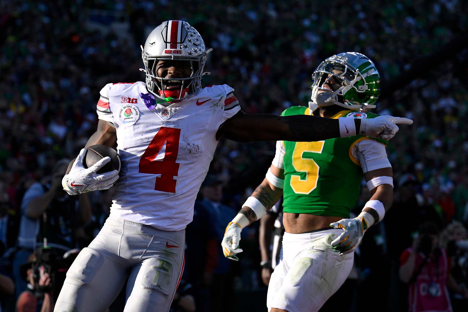 PASADENA, CALIFORNIA - JANUARY 1: Jeremiah Smith #4 of the Ohio State Buckeyes celebrates after scoring a touchdown ahead of Kobe Savage #5 of the Oregon Ducks at Rose Bowl Stadium on January 1, 2025 in Pasadena, California. (Photo by CFP/Getty Images)