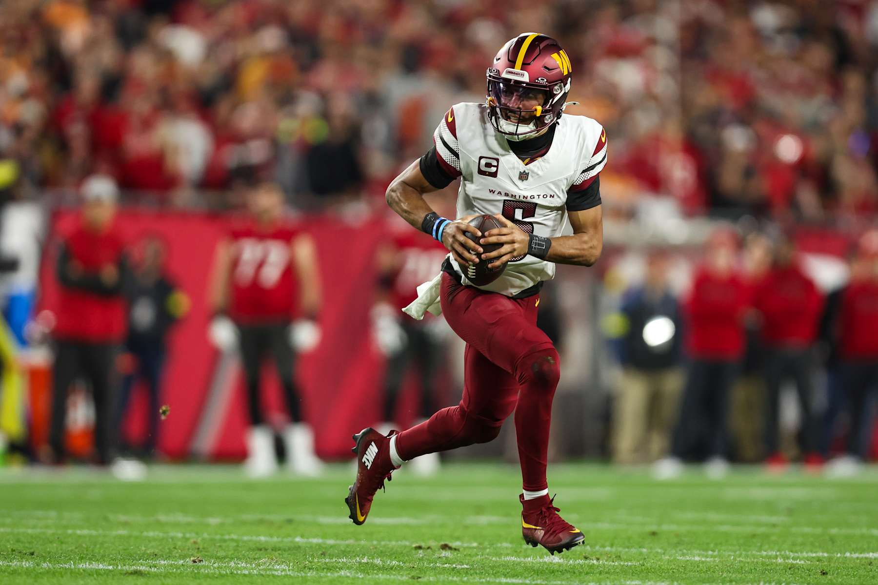 TAMPA, FLORIDA - JANUARY 12: Jayden Daniels #5 of the Washington Commanders scrambles out of the pocket during an NFL football wild card playoff game against the Tampa Bay Buccaneers at Raymond James Stadium on January 12, 2025 in Tampa, Florida. (Photo by Perry Knotts/Getty Images)