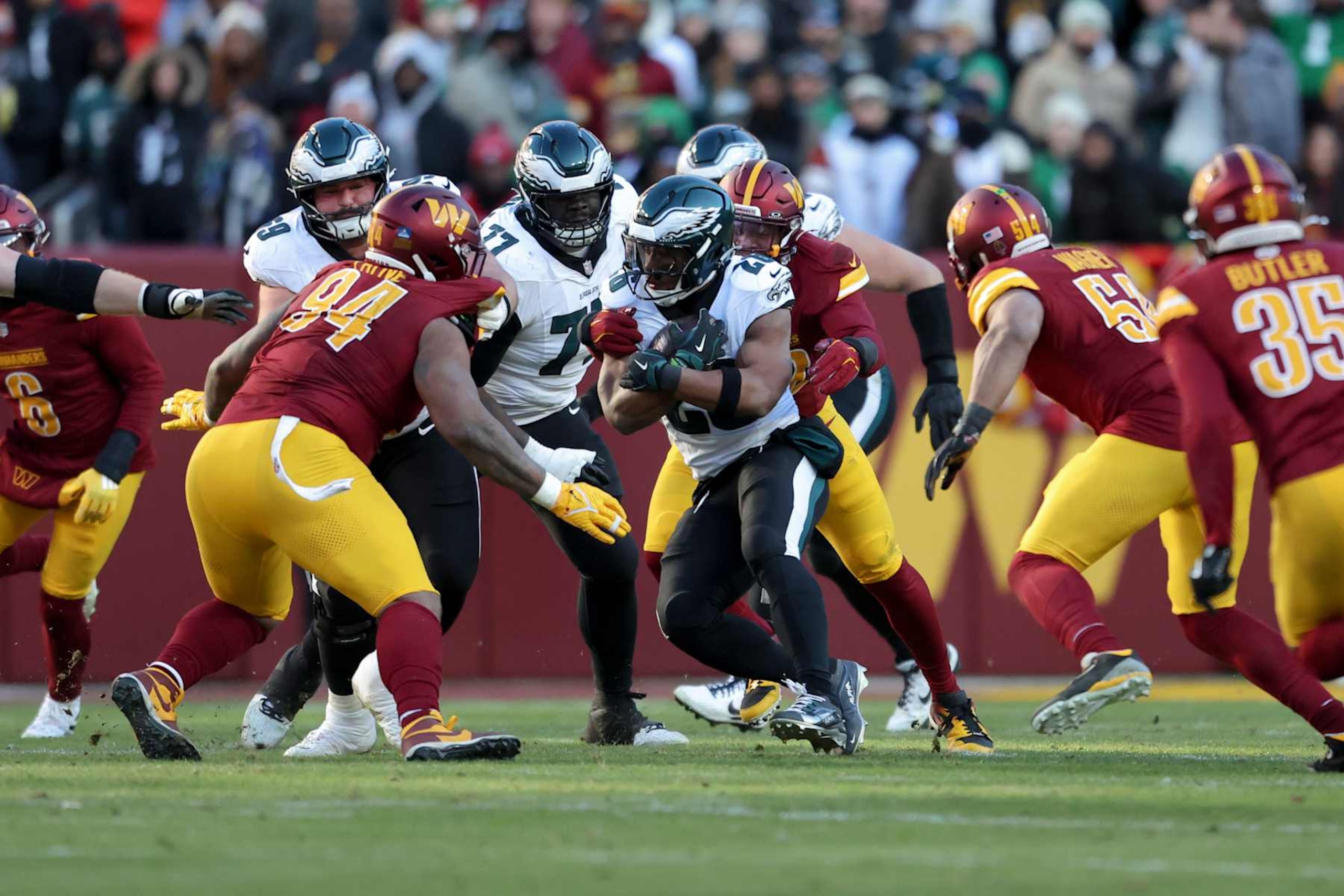LANDOVER, MARYLAND - DECEMBER 22: Saquon Barkley #26 of the Philadelphia Eagles is tackled while running the ball during a game against the Washington Commanders at Northwest Stadium on December 22, 2024 in Landover, Maryland. The Commanders defeated the Eagles 36-33. (Kara Durrette/Getty Images)