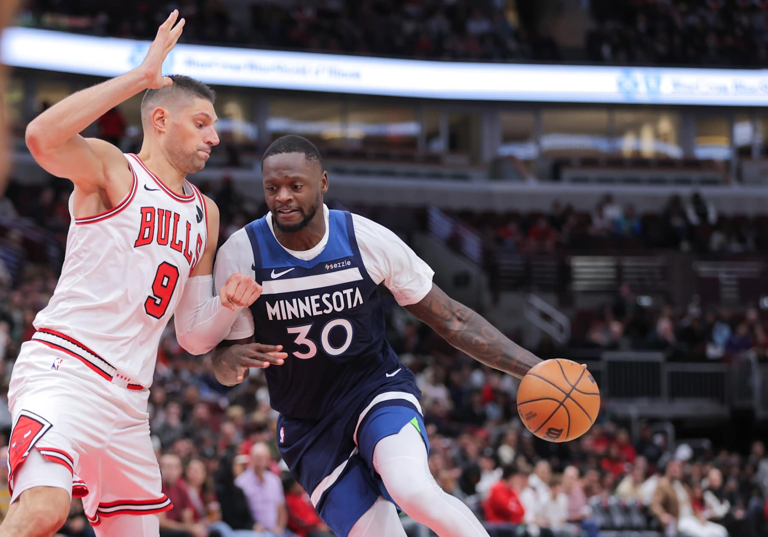 CHICAGO, IL - OCTOBER 16: Chicago Bulls center Nikola Vucevic (9) guards Minnesota Timberwolves forward Julius Randle (30) during the first half of a preseason game on October 16, 2024 at the United Center in Chicago, Illinois. (Photo by Melissa Tamez/Icon Sportswire via Getty Images)