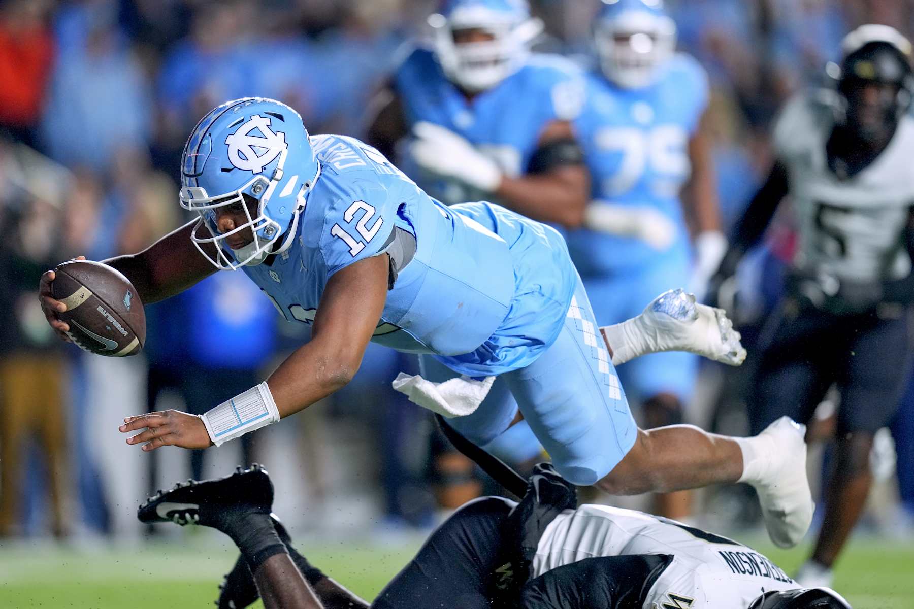 CHAPEL HILL, NORTH CAROLINA - NOVEMBER 16: Jacolby Criswell #12 of the North Carolina Tar Heels dives into the end zone for a touchdown Wake Forest Demon Deacons during the first half of the game at Kenan Memorial Stadium on November 16, 2024 in Chapel Hill, North Carolina.  (Photo by Grant Halverson/Getty Images)