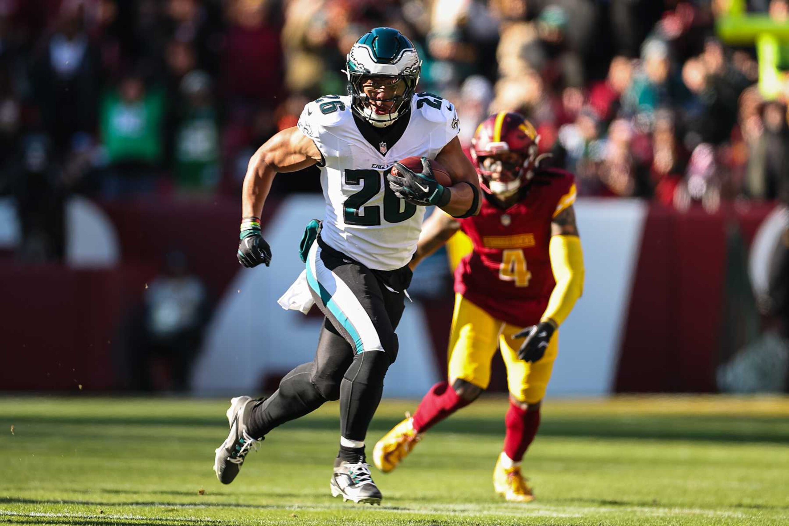 LANDOVER, MD - DECEMBER 22: Saquon Barkley #26 of the Philadelphia Eagles carries the ball against the Washington Commanders during the first half of the game at Northwest Stadium on December 22, 2024 in Landover, Maryland. (Photo by Scott Taetsch/Getty Images) LANDOVER, MD - DECEMBER 22: Saquon Barkley #26 of the Philadelphia Eagles carries the ball against the Washington Commanders during the first half of the game at Northwest Stadium on December 22, 2024 in Landover, Maryland. (Photo by Scott Taetsch/Getty Images)