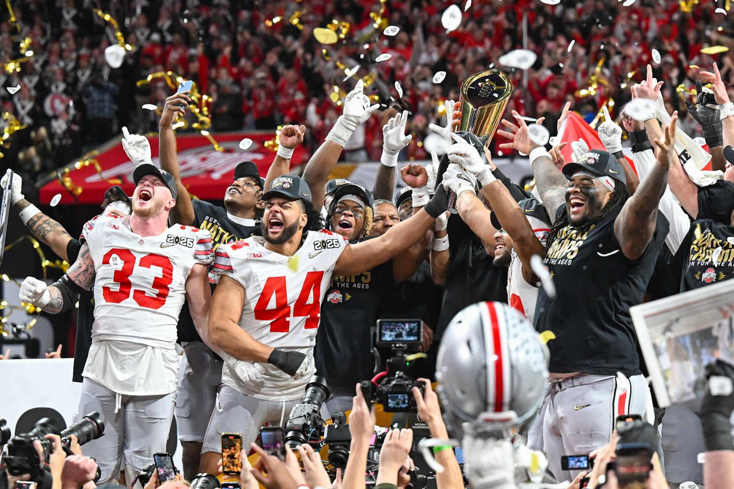 ATLANTA, GA JANUARY 20: Ohio State players celebrate with the winning trophy following the conclusion of the the Ohio State Buckeyes versus Notre Dame Fighting Irish College Football Playoff National Championship game on January 20, 2025, at Mercedes-Benz Stadium in Atlanta, GA. (Photo by Rich von Biberstein/Icon Sportswire via Getty Images) ATLANTA, GA JANUARY 20: Ohio State players celebrate with the winning trophy following the conclusion of the the Ohio State Buckeyes versus Notre Dame Fighting Irish College Football Playoff National Championship game on January 20, 2025, at Mercedes-Benz Stadium in Atlanta, GA. (Photo by Rich von Biberstein/Icon Sportswire via Getty Images)