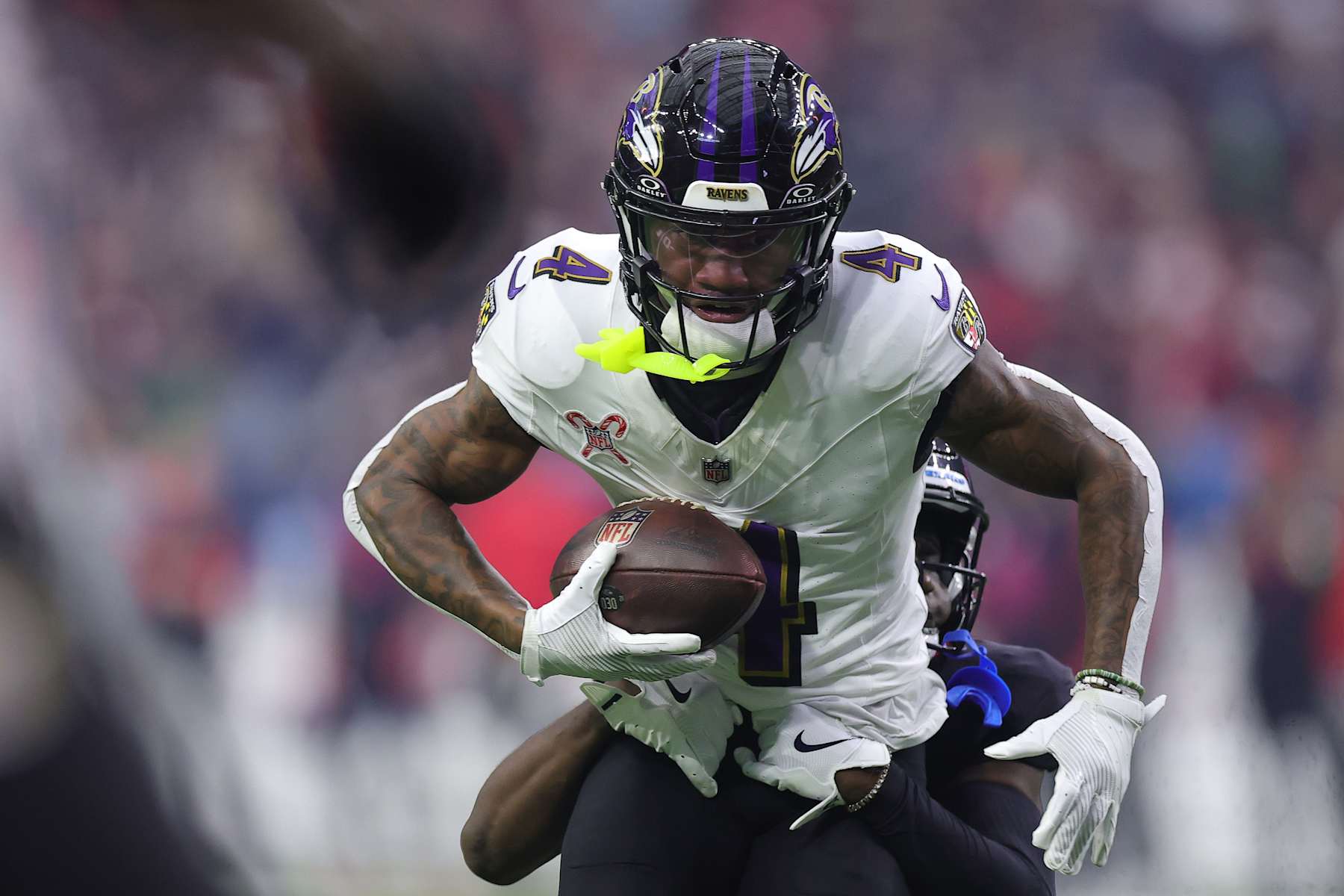HOUSTON, TEXAS - DECEMBER 25: Zay Flowers #4 of the Baltimore Ravens runs the ball after a catch Kamari Lassiter #4 of the Houston Texans during the first quarter at NRG Stadium on December 25, 2024 in Houston, Texas. (Photo by Alex Slitz/Getty Images)