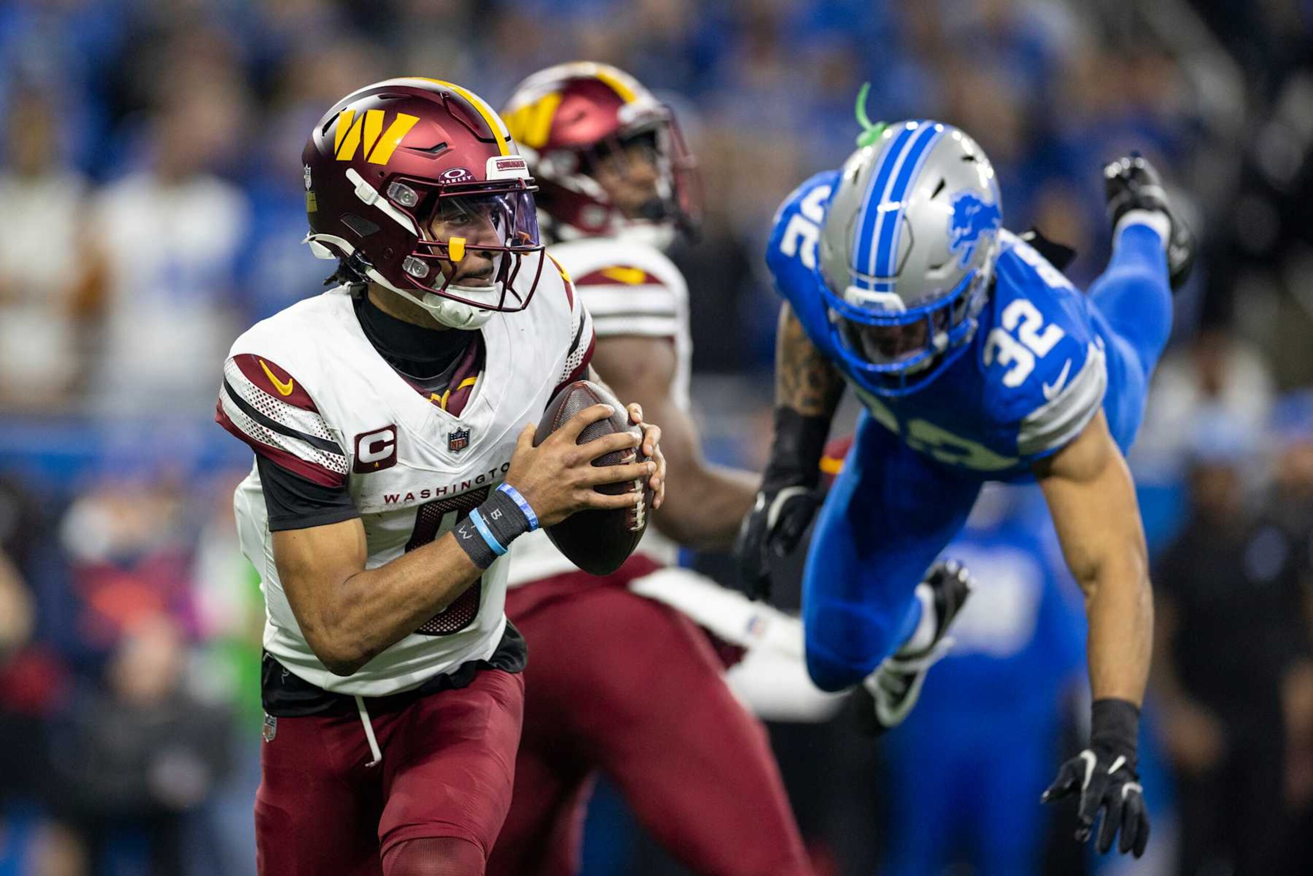 DETROIT, MICHIGAN - JANUARY 18: Jayden Daniels #5 of the Washington Commanders scrambles and looks to pass during an NFL Football game against the Detroit Lions at Ford Field on January 18, 2025 in Detroit, Michigan. (Photo by Michael Owens/Getty Images) DETROIT, MICHIGAN - JANUARY 18: Jayden Daniels #5 of the Washington Commanders scrambles and looks to pass during an NFL Football game against the Detroit Lions at Ford Field on January 18, 2025 in Detroit, Michigan. (Photo by Michael Owens/Getty Images)