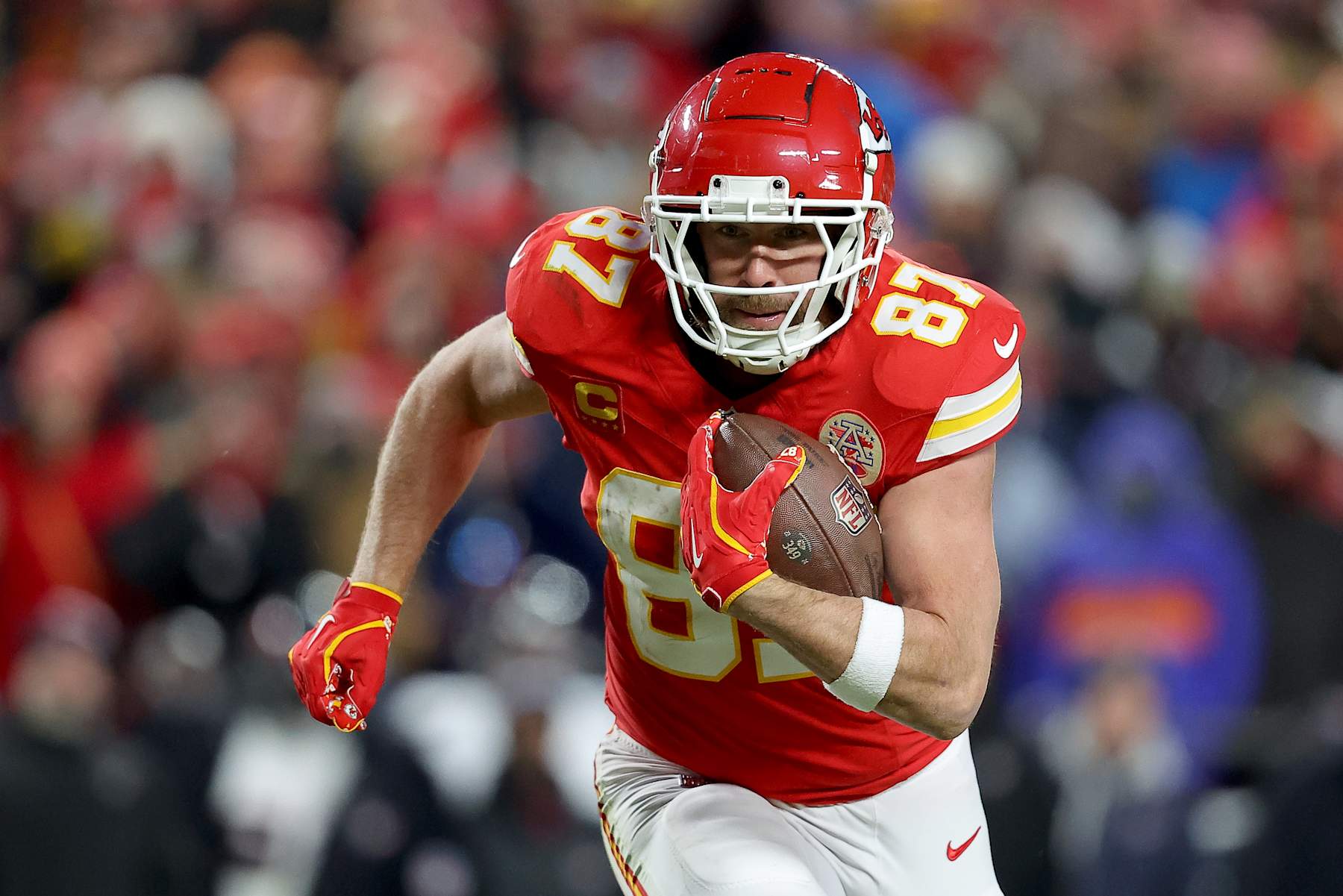 KANSAS CITY, MISSOURI - JANUARY 18: Travis Kelce #87 of the Kansas City Chiefs carries the ball against the Houston Texans during the fourth quarter in the AFC Divisional Playoff at GEHA Field at Arrowhead Stadium on January 18, 2025 in Kansas City, Missouri. (Photo by David Eulitt/Getty Images)