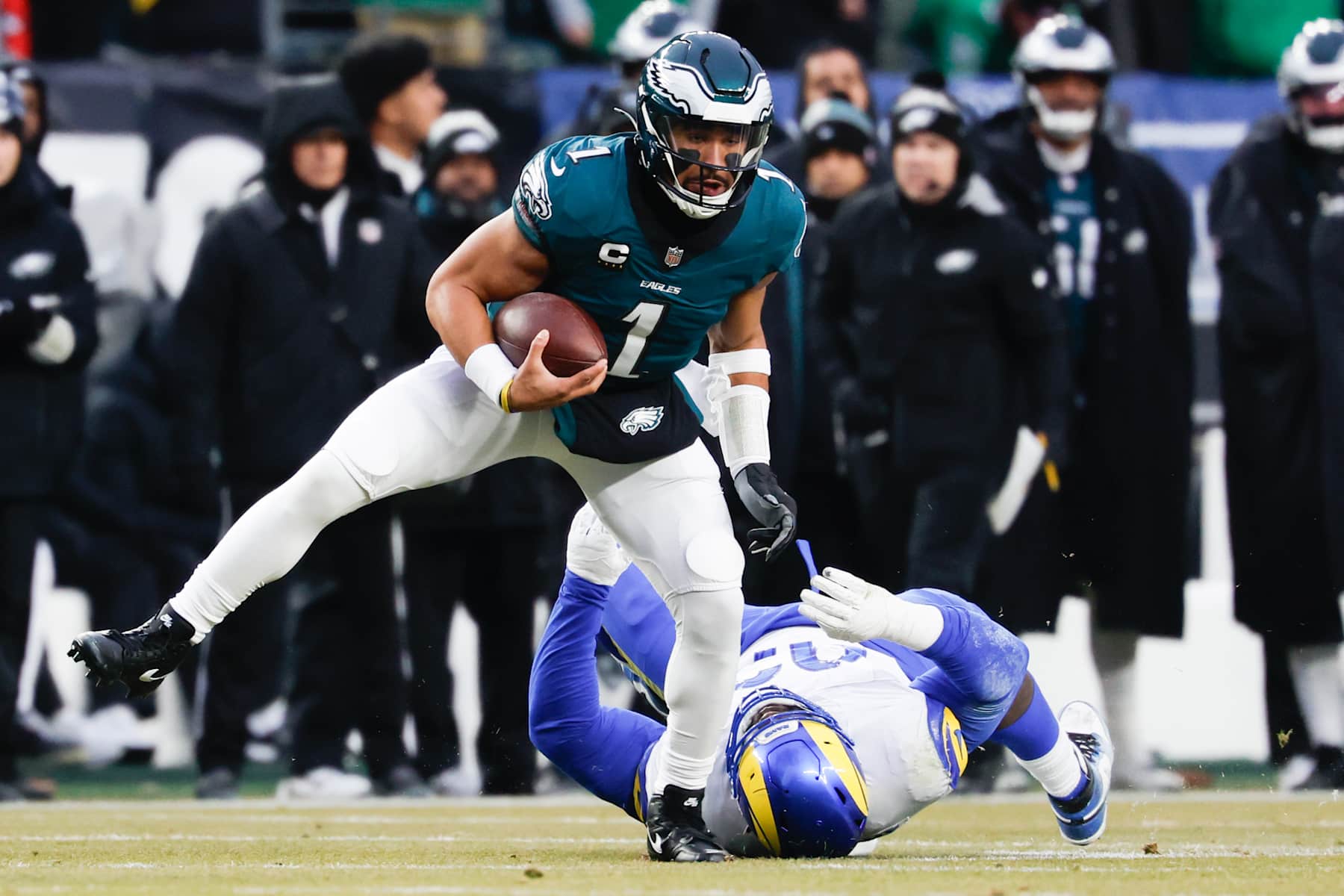 PHILADELPHIA, PA - JANUARY 19: Philadelphia Eagles quarterback Jalen Hurts, left, breaks a tackle from Los Angeles Rams defensive tackle Neville Gallimore to score a touchdown during the first quarter during an NFC divisional round at Lincoln Financial Field on Sunday, Jan. 19, 2025 in Philadelphia, PA. (Gina Ferazzi / Los Angeles Times via Getty Images)