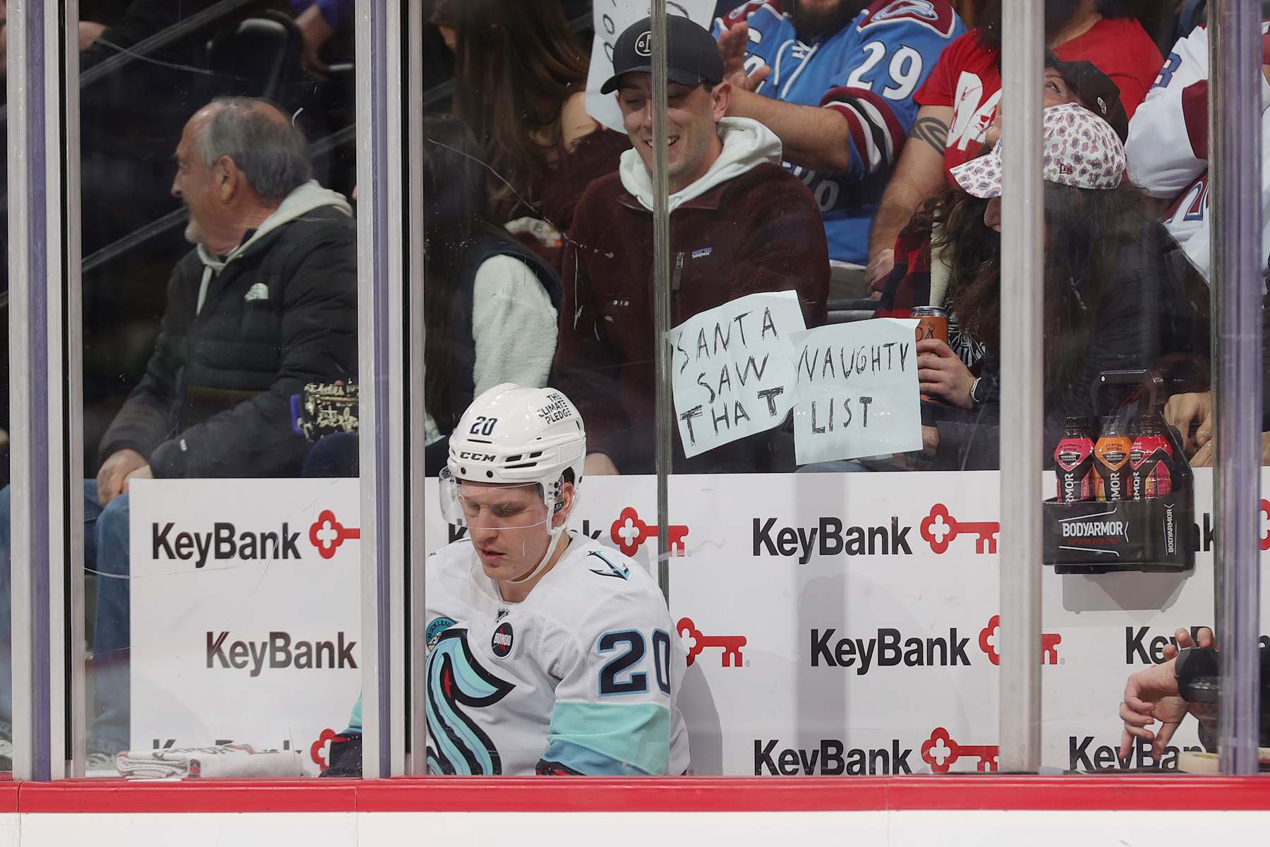 DENVER, COLORADO - DECEMBER 22: Eeli Tolvanen #20 of the Seattle Kraken sits in the penalty box in front of signs held up by fans during a game against Colorado Avalanche at Ball Arena on December 22, 2024 in Denver, Colorado. (Photo by Michael Martin/NHLI via Getty Images)