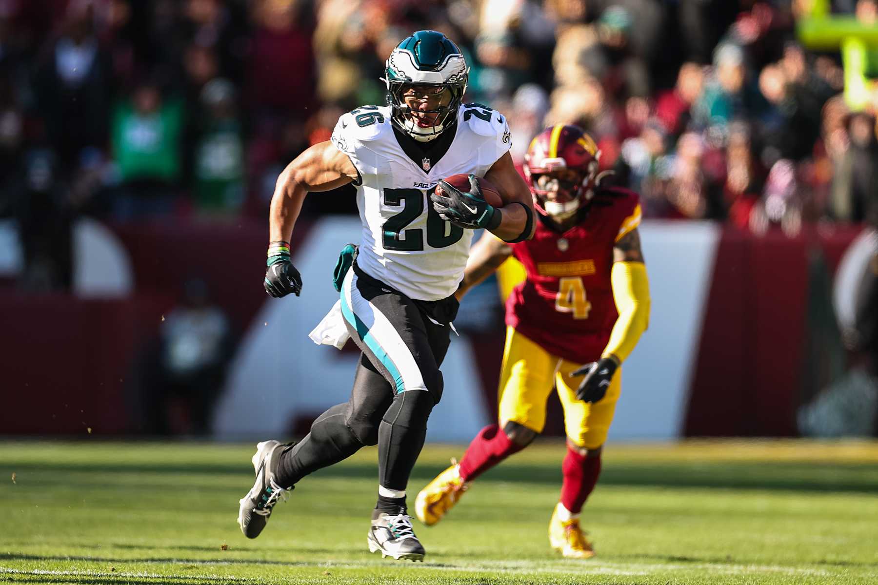LANDOVER, MD - DECEMBER 22: Saquon Barkley #26 of the Philadelphia Eagles carries the ball against the Washington Commanders during the first half of the game at Northwest Stadium on December 22, 2024 in Landover, Maryland. (Photo by Scott Taetsch/Getty Images)