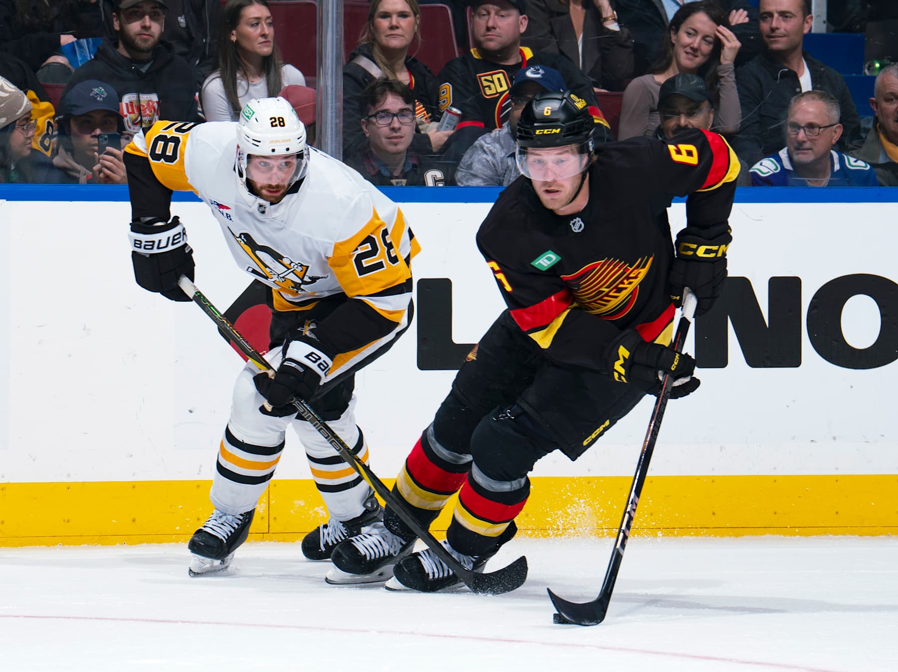 VANCOUVER, CANADA - OCTOBER 26: Marcus Pettersson #28 of the Pittsburgh Penguins checks Brock Boeser #6 of the Vancouver Canucks during their NHL game at Rogers Arena on October 26, 2024 in Vancouver, British Columbia, Canada.  (Photo by Jeff Vinnick/NHLI via Getty Images)