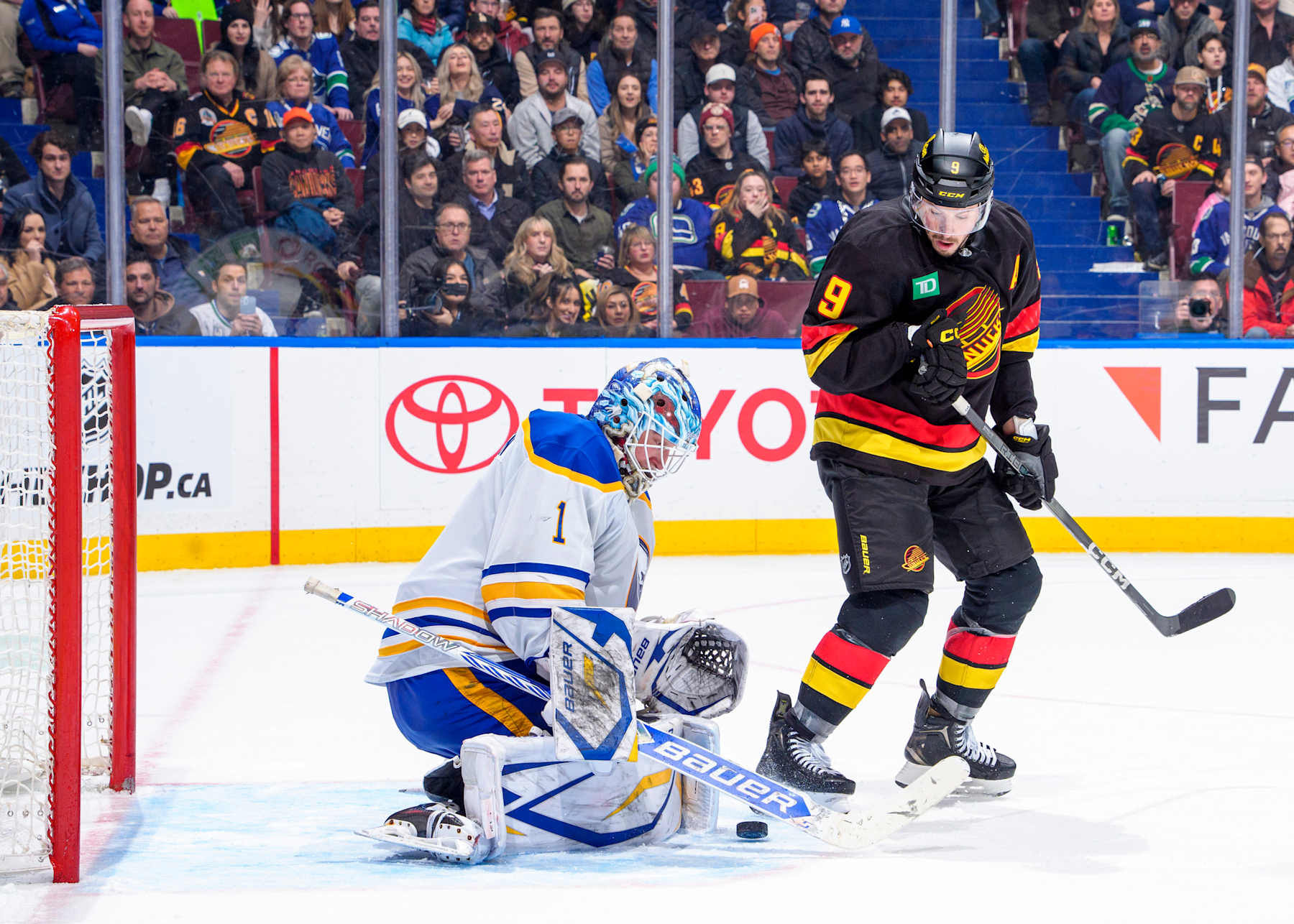 VANCOUVER, CANADA - JANUARY 21: Ukko-Pekka Luukkonen #1 of the Buffalo Sabres blocks a shot from J.T. Miller #9 of the Vancouver Canucks during the third period of their NHL game at Rogers Arena on January 21, 2025 in Vancouver, British Columbia, Canada.  (Photo by Jeff Vinnick/NHLI via Getty Images)