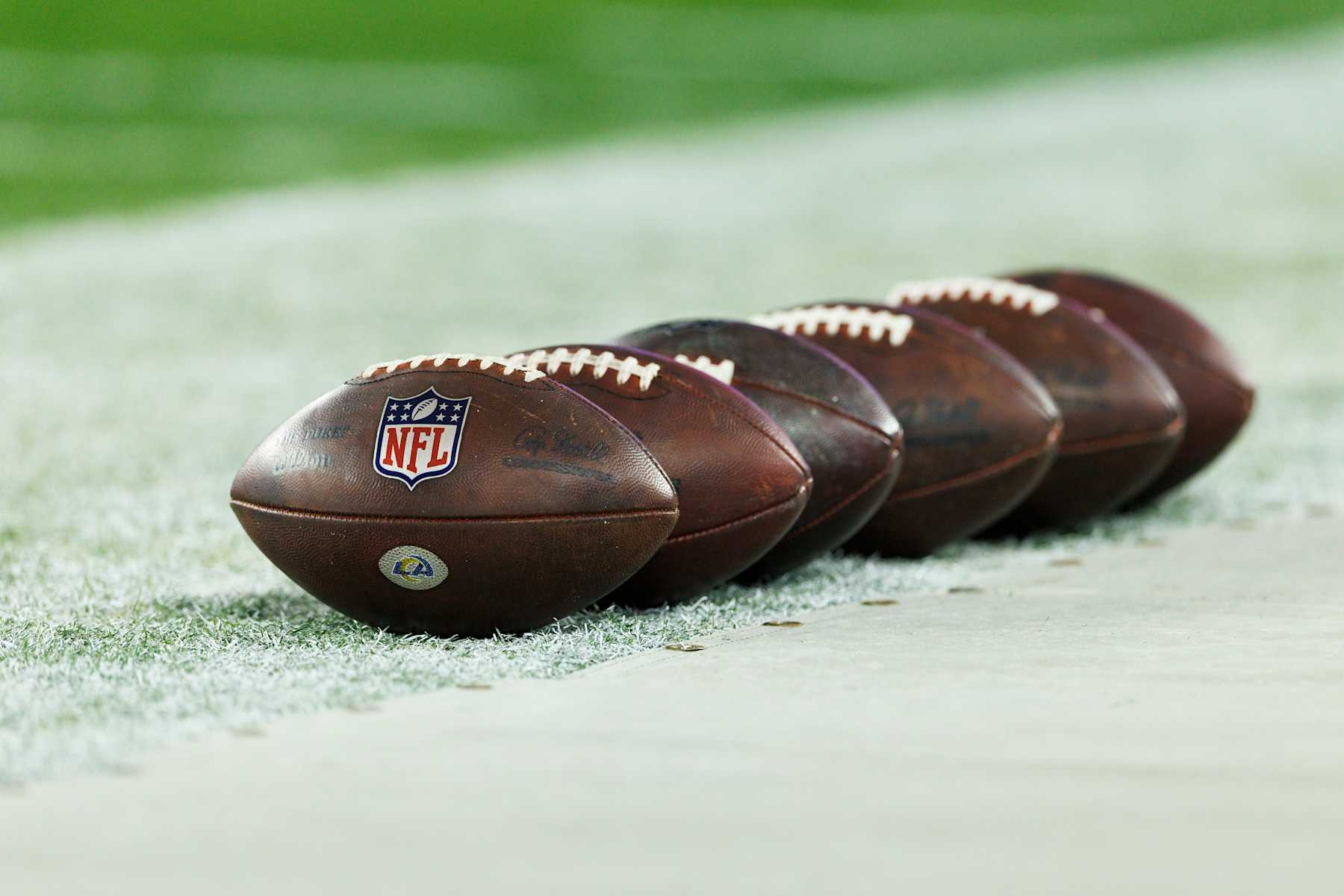 GLENDALE, ARIZONA - JANUARY 13: A detail view of a row of NFL footballs on the sideline before the NFC Wild Card Playoff game between the Minnesota Vikings and the Los Angeles Rams at State Farm Stadium on January 13, 2025 in Glendale, Arizona. (Photo by Ric Tapia/Getty Images)